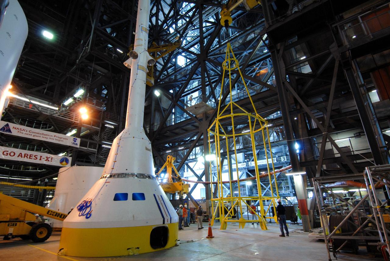 CAPE CANAVERAL, Fla. ––   In High Bay 4 of the Vehicle Assembly Building at NASA's Kennedy Space Center in Florida, the yellow framework at center will undergo a fit check.  Nicknamed the "birdcage," it is the lifting fixture that will have the ability to lift the Crew Module, or CM, and Launch Abort System, or LAS, assembly for the Ares I-X rocket. Ares I-X is the flight test for the Ares I. The I-X flight will provide NASA an early opportunity to test and prove hardware, facilities and ground operations associated with Ares I.  The launch of the 327-foot-tall, full-scale Ares I-X is targeted for July 2009.  Photo credit: NASA/Jack Pfaller