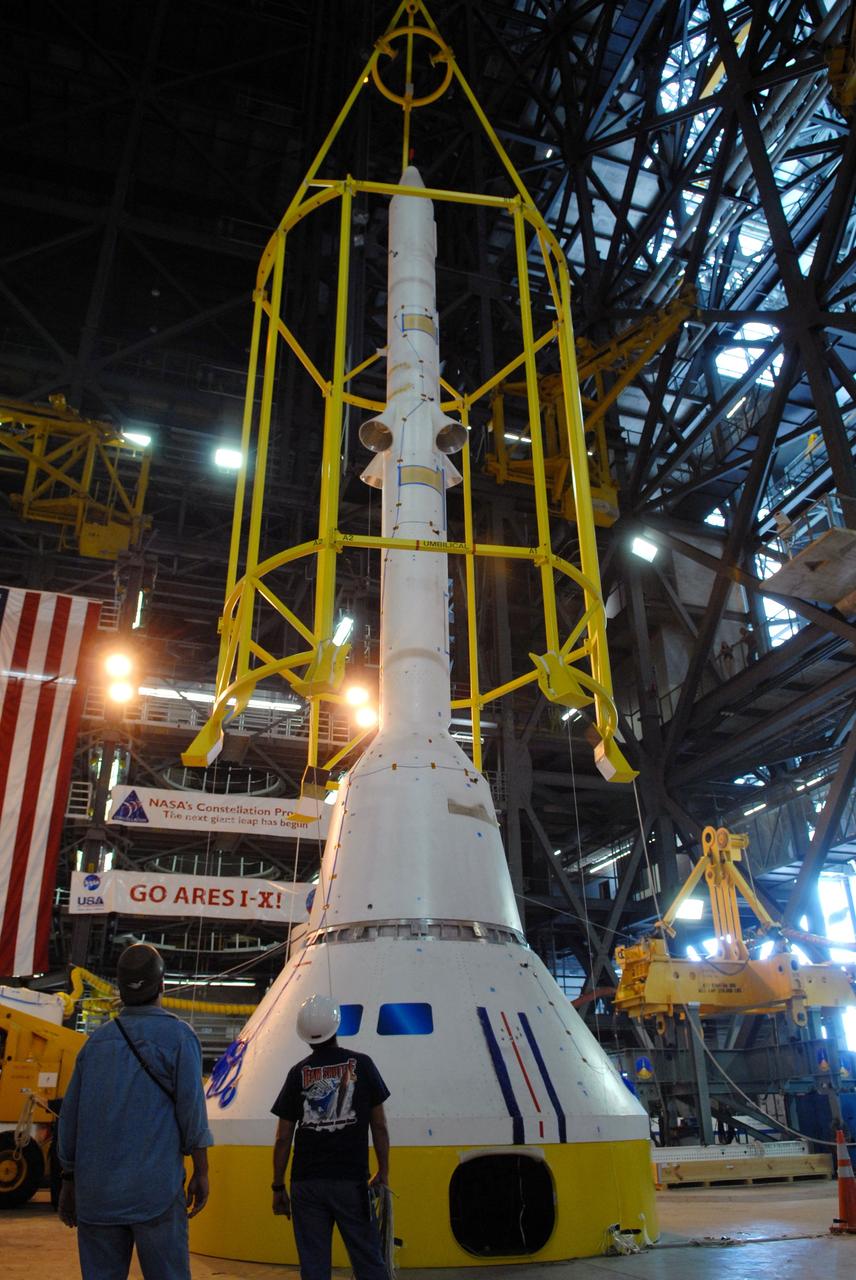 CAPE CANAVERAL, Fla. ––  In High Bay 4 of the Vehicle Assembly Building at NASA's Kennedy Space Center in Florida, the yellow framework , nicknamed the "birdcage," is lowered over the Crew Module, or CM, and Launch Abort System, or LAS, assembly for a fit check.  Ares I-X is the flight test for the Ares I. The I-X flight will provide NASA an early opportunity to test and prove hardware, facilities and ground operations associated with Ares I.  The launch of the 327-foot-tall, full-scale Ares I-X is targeted for July 2009.  Photo credit: NASA/Jack Pfaller
