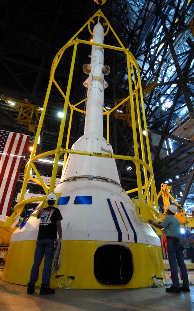 CAPE CANAVERAL, Fla. ––  In High Bay 4 of the Vehicle Assembly Building at NASA's Kennedy Space Center in Florida, the yellow framework , nicknamed the "birdcage," is lowered over the Crew Module, or CM, and Launch Abort System, or LAS, assembly for a fit check.  Ares I-X is the flight test for the Ares I. The I-X flight will provide NASA an early opportunity to test and prove hardware, facilities and ground operations associated with Ares I.  The launch of the 327-foot-tall, full-scale Ares I-X is targeted for July 2009.  Photo credit: NASA/Jack Pfaller