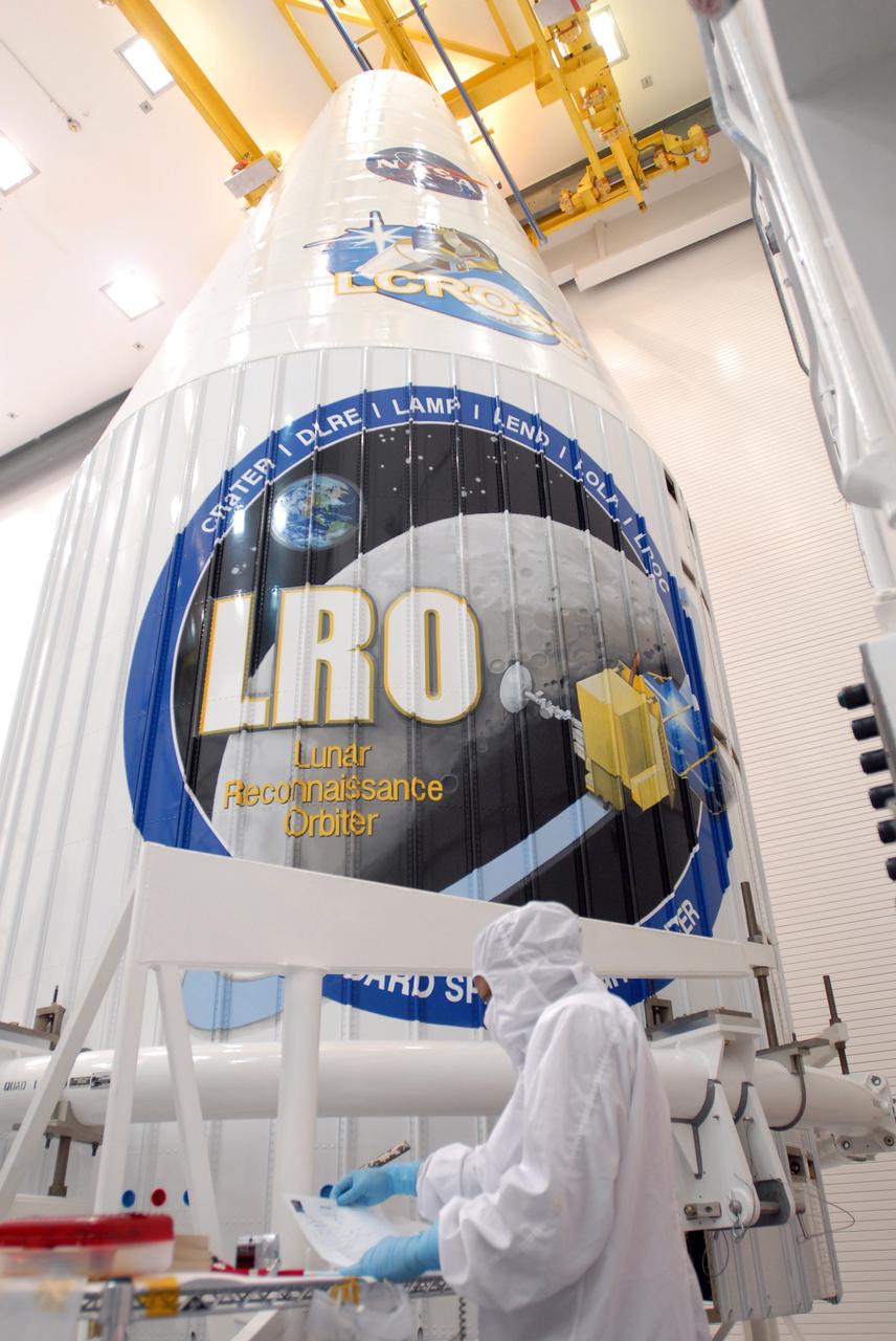 CAPE CANAVERAL, Fla. –– At Astrotech Space Operations in Titusville, Fla., a technician prepares for the installation of the solar array panel on the Lunar Reconnaissance Orbiter, or LRO.  He stands in front of the fairing that will encapsulate the spacecraft at a later date. The orbiter will carry seven instruments to provide scientists with detailed maps of the lunar surface and enhance our understanding of the moon's topography, lighting conditions, mineralogical composition and natural resources. Information gleaned from LRO will be used to select safe landing sites, determine locations for future lunar outposts and help mitigate radiation dangers to astronauts. The polar regions of the moon are the main focus of the mission because continuous access to sunlight may be possible and water ice may exist in permanently shadowed areas of the poles. Launch of LRO is targeted for June 2.  Photo credit: NASA/Jim Grossmann