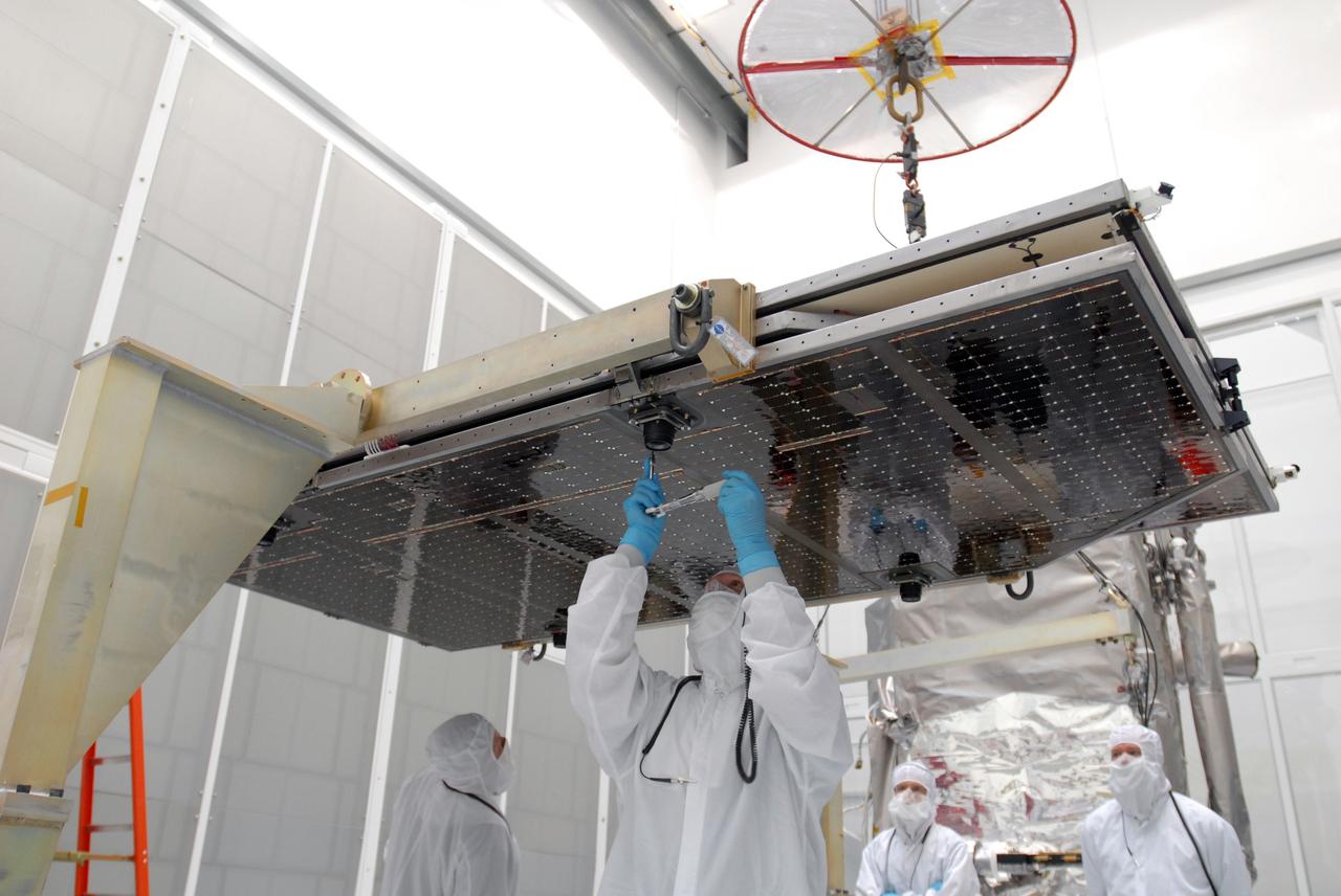CAPE CANAVERAL, Fla. –– At Astrotech Space Operations in Titusville, Fla., technicians prepare the solar array panel for installation on the Lunar Reconnaissance Orbiter, or LRO. The orbiter will carry seven instruments to provide scientists with detailed maps of the lunar surface and enhance our understanding of the moon's topography, lighting conditions, mineralogical composition and natural resources. Information gleaned from LRO will be used to select safe landing sites, determine locations for future lunar outposts and help mitigate radiation dangers to astronauts. The polar regions of the moon are the main focus of the mission because continuous access to sunlight may be possible and water ice may exist in permanently shadowed areas of the poles. Launch of LRO is targeted for June 2.  Photo credit: NASA/Jim Grossmann