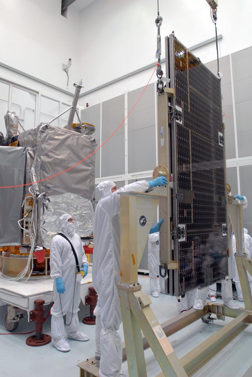 CAPE CANAVERAL, Fla. –– At Astrotech Space Operations in Titusville, Fla., technicians prepare the solar array panel for installation on the Lunar Reconnaissance Orbiter, or LRO, at  left. The orbiter will carry seven instruments to provide scientists with detailed maps of the lunar surface and enhance our understanding of the moon's topography, lighting conditions, mineralogical composition and natural resources. Information gleaned from LRO will be used to select safe landing sites, determine locations for future lunar outposts and help mitigate radiation dangers to astronauts. The polar regions of the moon are the main focus of the mission because continuous access to sunlight may be possible and water ice may exist in permanently shadowed areas of the poles. Launch of LRO is targeted for June 2.  Photo credit: NASA/Jim Grossmann