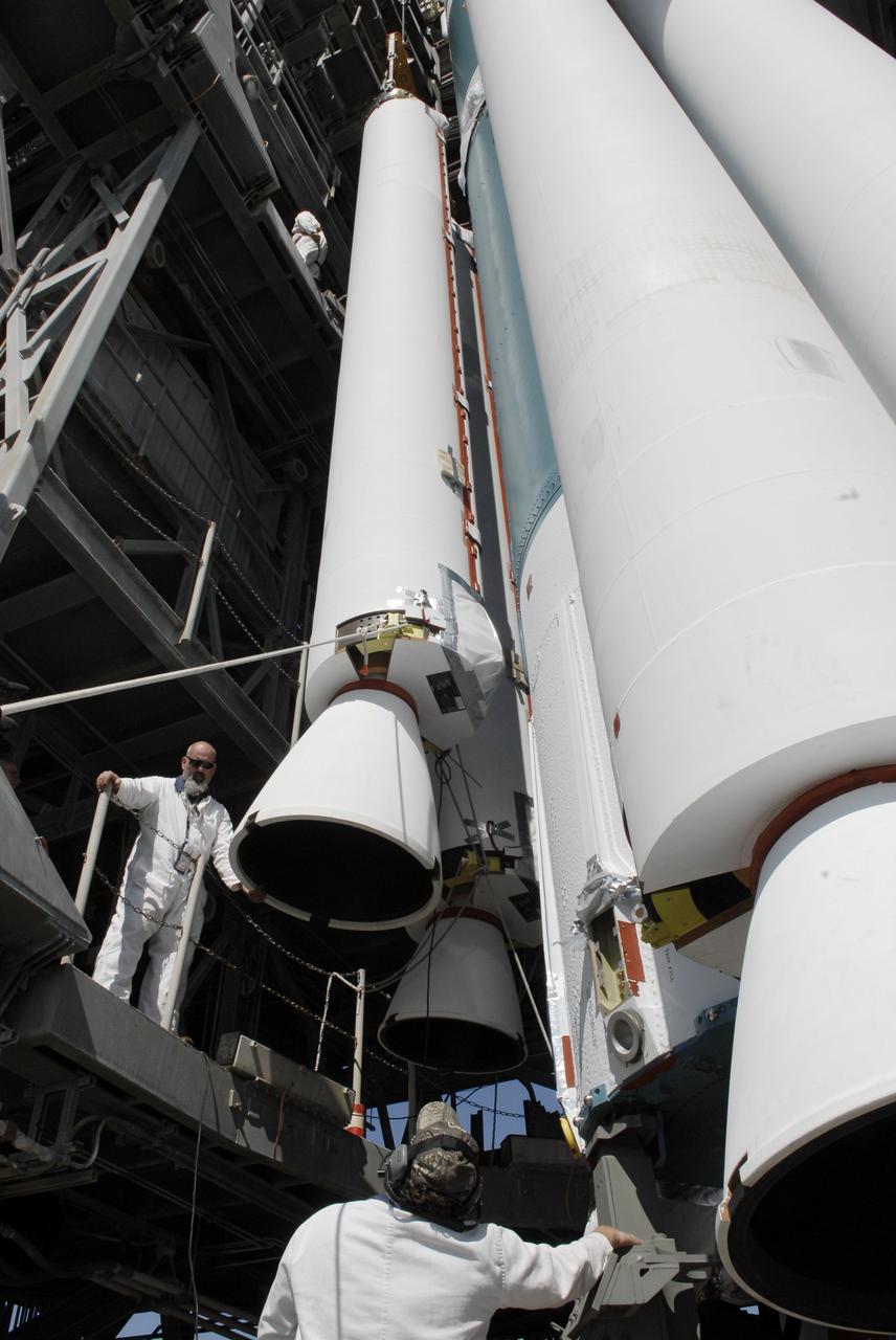 CAPE CANAVERAL, Fla. – On Launch Pad 17-B at Cape Canaveral Air Force Station, workers monitor the placement of a solid rocket booster on a Delta II rocket for launch of the STSS Demonstrator spacecraft. The spacecraft is a midcourse tracking technology demonstrator, part of an evolving ballistic missile defense system. STSS is capable of tracking objects after boost phase and provides trajectory information to other sensors. It will be launched by NASA for the Missile Defense Agency on July 29. Photo credit: NASA/Kim Shiflett