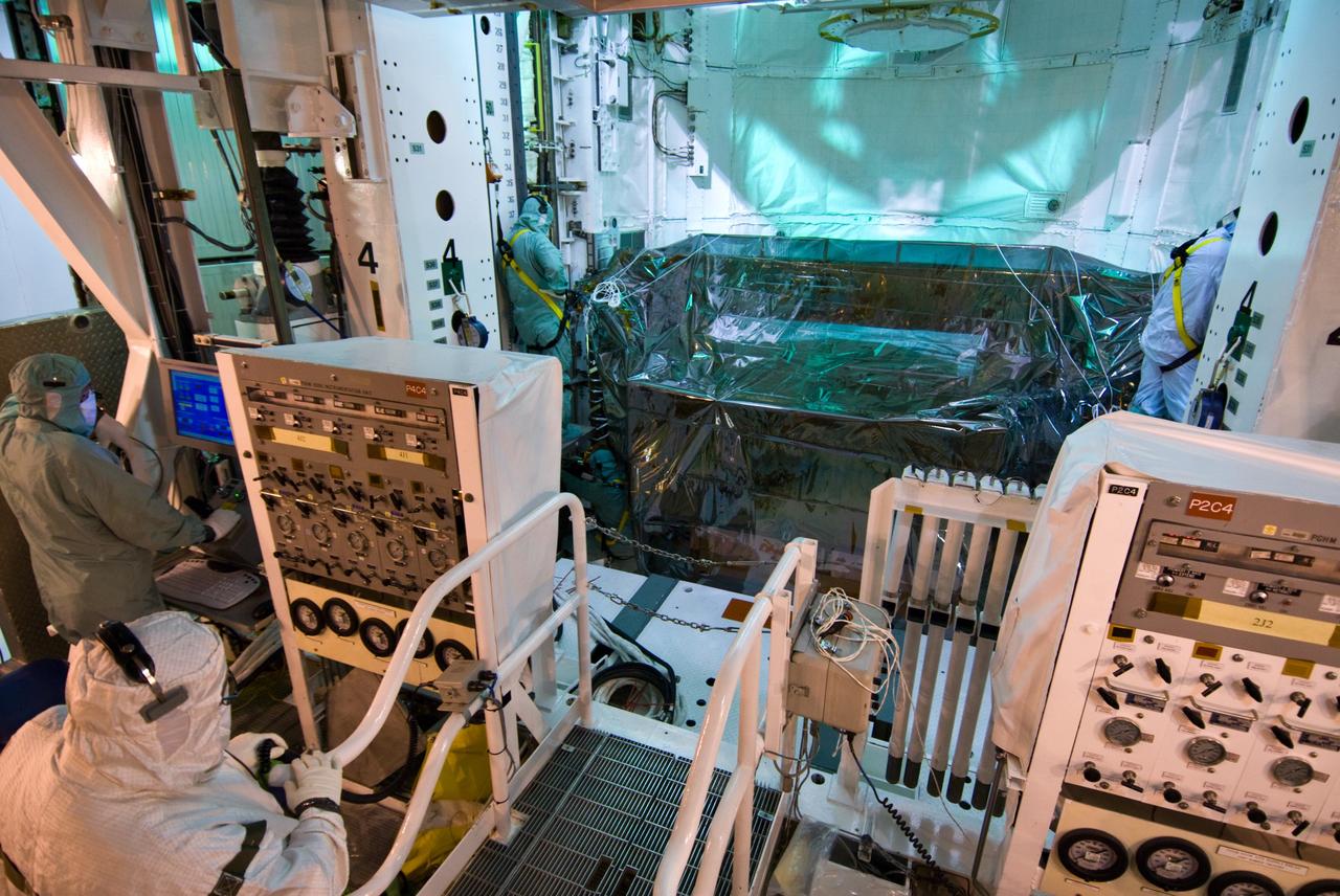 CAPE CANAVERAL, Fla. –– On Launch Pad 39A at NASA's Kennedy Space Center in Florida, workers install the equipment and hardware needed to service the Hubble Space Telescope into space shuttle Atlantis' payload bay. Launch of Atlantis' 11-day STS-125 mission to Hubble is targeted for May 12. The flight will include five spacewalks during which astronauts will refurbish and upgrade the telescope with state-of-the-art science instruments. As a result, Hubble's capabilities will be expanded and its operational lifespan extended through at least 2014. Photo credit: NASA/Jack Pfaller