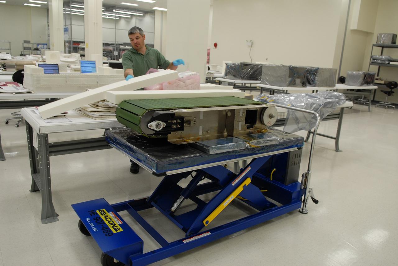 CAPE CANAVERAL, Fla. –– In the Space Station Processing Facility at NASA's Kennedy Space Center in Florida, a worker prepares to pack the Combined Operational Load Bearing External Resistance Treadmill, or COLBERT, for launch to the International Space Station on the space shuttle Discovery STS-128 mission. The treadmill is named after comedian Stephen Colbert, the host of Comedy Central’s “The Colbert Report.” Colbert urged his viewers to suggest the name “Colbert” as the name for the station’s Node 3 module. Although his name did receive the most entries in an Internet polling contest, NASA chose the name “Tranquility” to honor the accomplishments of the Apollo 11 mission. COLBERT will be installed in Tranquility after the node arrives at the station next year. Launch of STS-128 is targeted for Aug. 6, 2009. Photo credit: NASA/Jack Pfaller