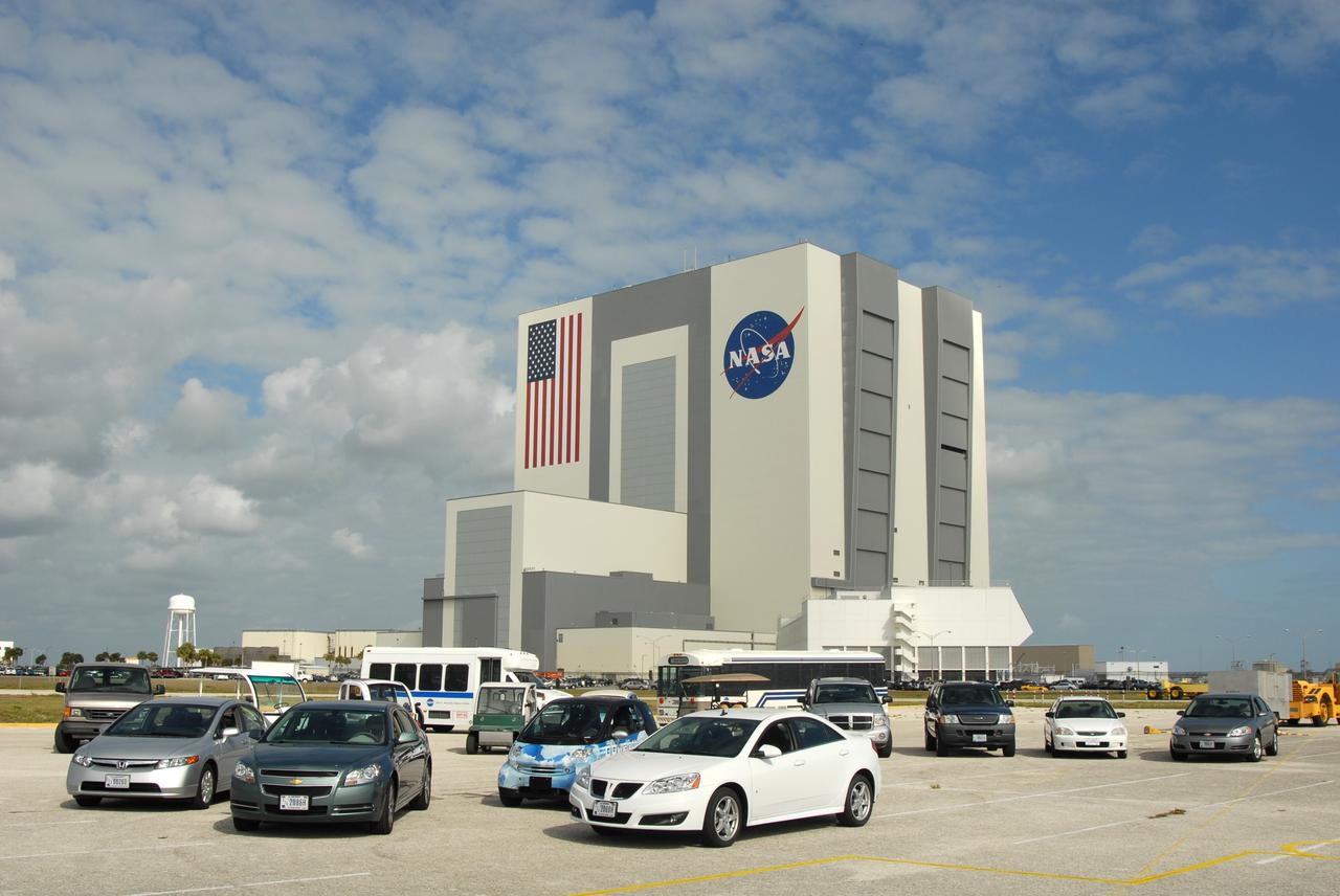 CAPE CANAVERAL, Fla. –– A variety of alternative fuel vehicles are driven around NASA's Kennedy Space Center in Florida  in an effort to reduce gasoline consumption and conserve energy. These include compressed natural gas, bi-fuel, diesel fuel and flex fuel vehicles.  Here they are on display at the NASA News Center.  In the background is the Vehicle Assembly Building.  Photo credit: NASA/Jim Grossmann