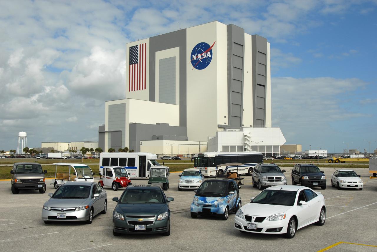 CAPE CANAVERAL, Fla. –– A variety of alternative fuel vehicles are driven around NASA's Kennedy Space Center in Florida  in an effort to reduce gasoline consumption and conserve energy. These include compressed natural gas, bi-fuel, diesel fuel and flex fuel vehicles.  Here they are on display at the NASA News Center.  In the background is the Vehicle Assembly Building.   Photo credit: NASA/Jim Grossmann