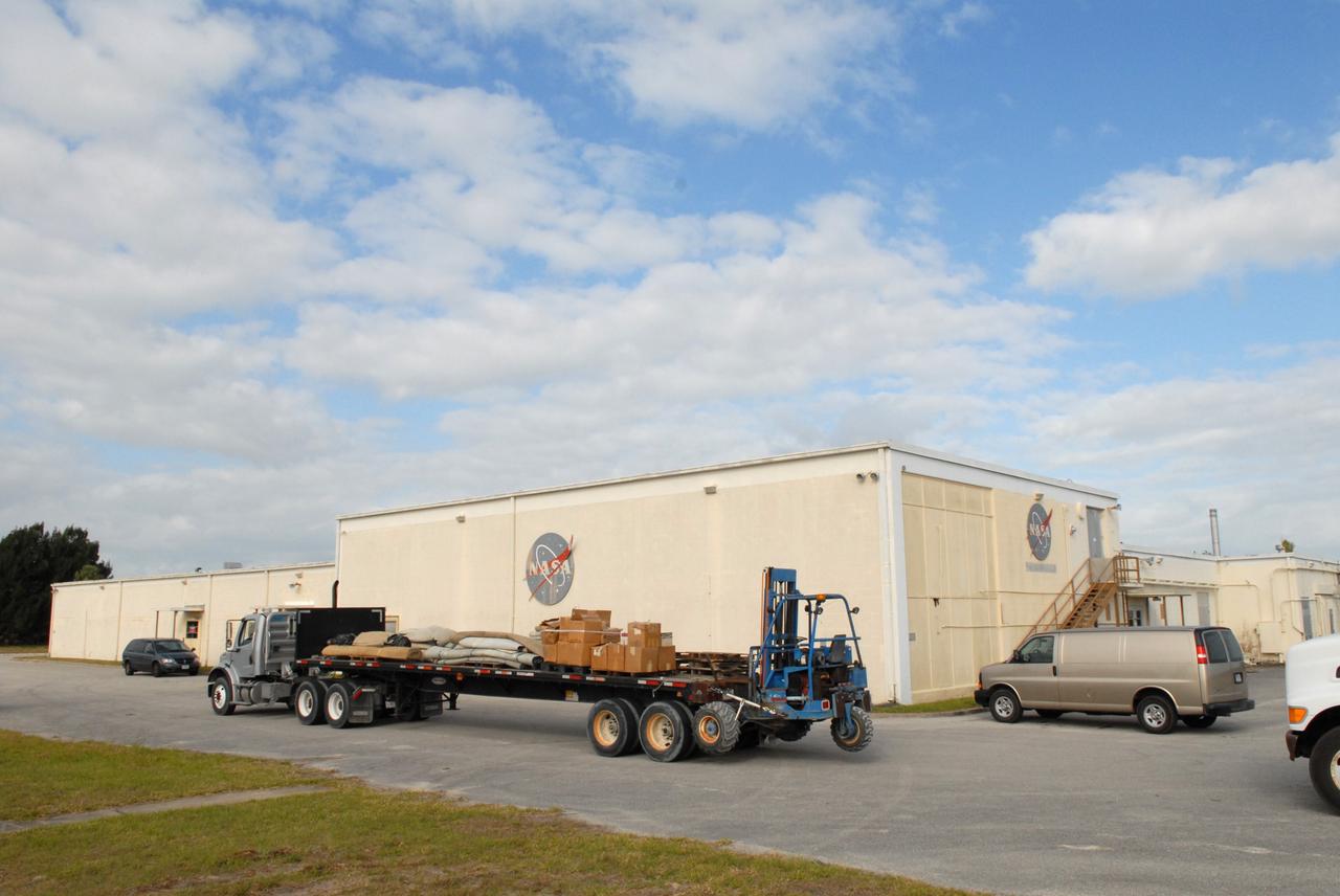 CAPE CANAVERAL, Fla. – A trailer hauls boxes and equipment from the 50-year-old Mission Control Center on the Cape Canaveral Air Force Station in Florida. Out of use for many years, and with no valid operational or other use for the facility, NASA plans to demolish the site. The facility once controlled all manned Mercury space flights and the first two unmanned Gemini flights from May 1961-1963. It provided launch, orbital, re-entry and landing control for the flights. That function was later transferred to NASA's Johnson Space Center in Houston. Photo credit: NASA/Jack Pfaller