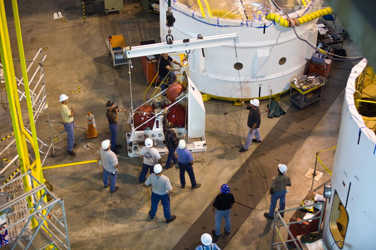 CAPE CANAVERAL, Fla. –– In High Bay 4 of the Vehicle Assembly Building at NASA's Kennedy Space Center in Florida, technicians maneuver the crane that will lift a second roll control system module for installation in an Ares I-X segment. Ares I-X is the test vehicle for the Ares I, which is part of the Constellation Program to return men to the moon and beyond. Ares I-X is targeted for launch in August 2009.  Photo credit: NASA/Dimitri Gerondidakis