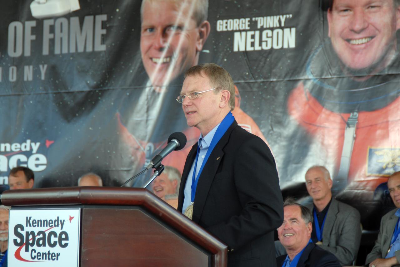 CAPE CANAVERAL, Fla. –– New inductee astronaut George "Pinky" Nelson addresses the spectators at the U.S. Astronaut Hall of Fame ceremony held at NASA's Kennedy Space Center Visitor Complex in Florida. Nelson was one of only six space shuttle astronauts to fly untethered in space using NASA's Manned Maneuvering Unit. The ceremony took place May 2. More than 20 hall of fame astronauts attended, including Scott Carpenter, Walt Cunningham, Jim Lovell and Bob Crippen. Photo credit: NASA/Jim Grossmann
