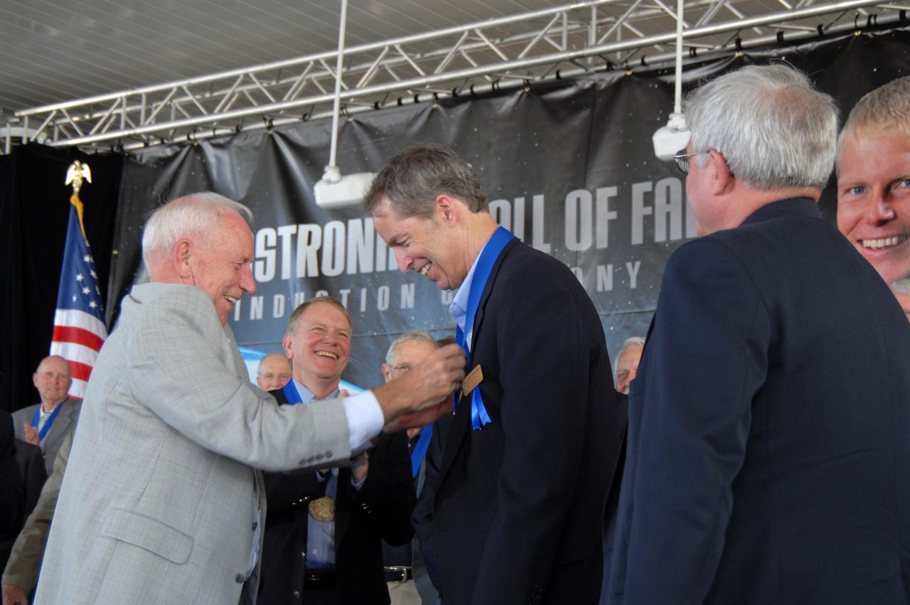 CAPE CANAVERAL, Fla. –– U.S. Astronaut Hall of Fame member Al Worden presents a medal to James Wetherbee as a new inductee into the hall of fame.  The ceremony was held at NASA's Kennedy Space Center Visitor Complex in Florida. Wetherbee was commander of the longest-docked shuttle-Mir mission. The ceremony took place May 2. More than 20 hall of fame astronauts attended, including Scott Carpenter, Walt Cunningham, Jim Lovell and Bob Crippen. Photo credit: NASA/Jim Grossmann