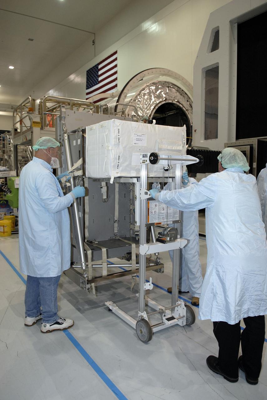 CAPE CANAVERAL, Fla. – In the Space Station Processing Facility at NASA's Kennedy Space Center in Florida,  technicians maneuver the Resupply Stowage Platform, or RSP, toward the rack insertion device.  The device will help install the RSP in the multi-purpose logistics module Leonardo. The module is part of the payload for space shuttle Discovery's STS-128 mission. Discovery will carry science and storage racks to the International Space Station . Launch of Discovery is targeted for Aug. 6.  Photo credit: NASA/Kim Shiflett