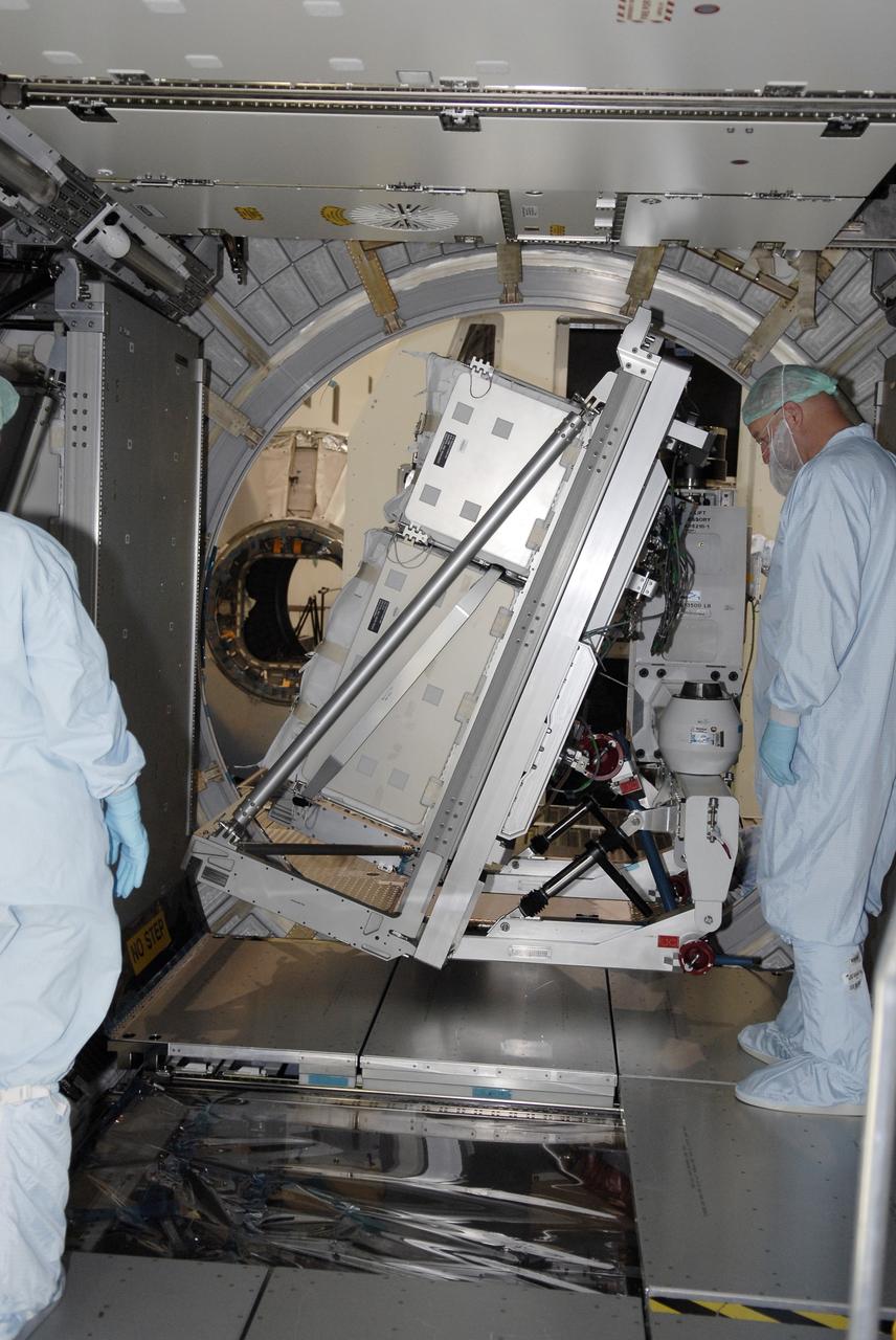 CAPE CANAVERAL, Fla. – In the Space Station Processing Facility at NASA's Kennedy Space Center in Florida,  technicians watch as the rack insertion device maneuvers the Resupply Stowage Platform, or RSP, into the multi-purpose logistics module Leonardo. The module is part of the payload for space shuttle Discovery's STS-128 mission. Discovery will carry science and storage racks to the International Space Station . Launch of Discovery is targeted for Aug. 6.  Photo credit: NASA/Kim Shiflett