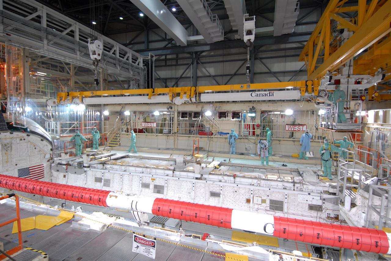 CAPE CANAVERAL, Fla. –  In Orbiter Processing Facility bay 3 at NASA's Kennedy Space Center in Florida, the remote manipulator system, or RMS, arm is lifted away from the payload bay of space shuttle Discovery. The RMS is used to grab, or grapple, the payload as well as retrieve, repair and deploy satellites; provide a mobile extension ladder for spacewalking crewmembers; and be used as an inspection aid to allow flight crew members to view the orbiter’s or payload’s surfaces through a TV camera on the arm.  Discovery is targeted to launch Aug. 6 on the STS-128 mission.  Photo credit: NASA/Jack Pfaller