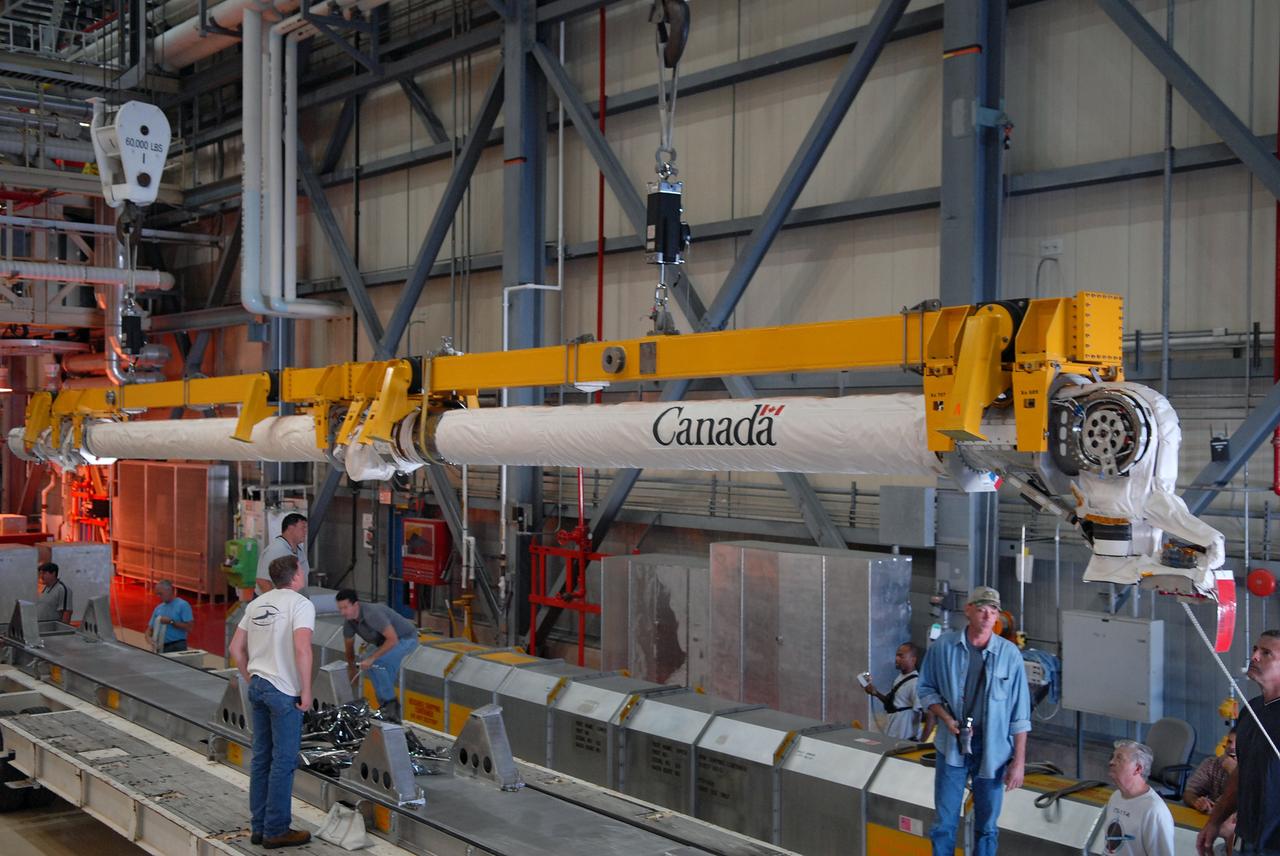 CAPE CANAVERAL, Fla. –  In Orbiter Processing Facility bay 3 at NASA's Kennedy Space Center in Florida, the remote manipulator system, or RMS, removed from space shuttle Discovery is lowered toward a storage platform.  The RMS is used to grab, or grapple, the payload as well as retrieve, repair and deploy satellites; provide a mobile extension ladder for spacewalking crewmembers; and be used as an inspection aid to allow flight crew members to view the orbiter’s or payload’s surfaces through a TV camera on the arm.  Discovery is targeted to launch Aug. 6 on the STS-128 mission.  Photo credit: NASA/Jack Pfaller