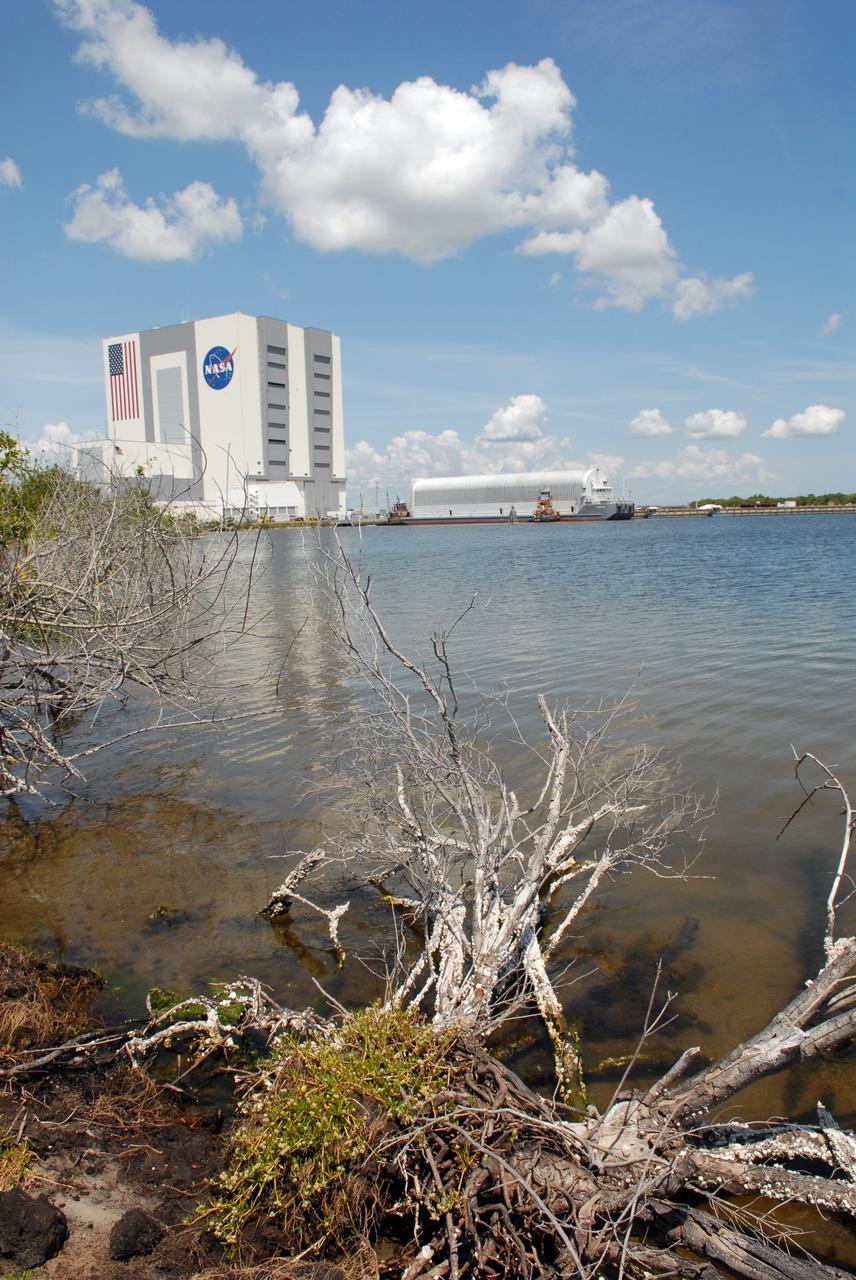 CAPE CANAVERAL, Fla. – Viewed from across the turn basin in the Launch Complex 39 Area at NASA's Kennedy Space Center in Florida, the Pegasus barge is maneuvered up to the dock.  In the background at left is the Vehicle Assembly Building.  The barge holds the external fuel tank, ET- 132, designated for space shuttle Discovery on the STS-128 mission.  The tank will be offloaded and transported to a high bay in the VAB for checkout. On the STS-128 mission, Discovery will carry science and storage racks to the International Space Station. Launch of Discovery is targeted for Aug. 6.  Photo credit: NASA/Troy Cryder