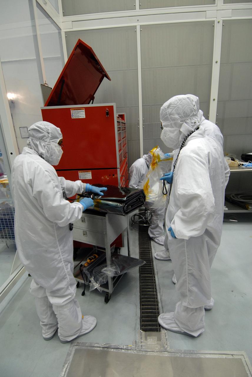 CAPE CANAVERAL, Fla. – At Astrotech Space Operations in Titusville, Fla.,  technicians remove the bag that will be placed over the Lunar Reconnaissance Orbiter, or LRO, before it is mated with NASA's Lunar CRater Observation and Sensing Satellite, known as LCROSS, spacecraft.  The satellite's primary mission is to search for water ice on the moon in a permanently shadowed crater near one of the lunar poles. LCROSS is a low-cost, accelerated-development, companion mission to NASA's Lunar Reconnaissance Orbiter, or LRO. LCROSS and LRO are the first missions in NASA's plan to return humans to the moon and begin establishing a lunar outpost by 2020. Launch is targeted for no earlier than June 2 from Cape Canaveral Air Force Station in Florida. Photo credit: NASA/Jack Pfaller