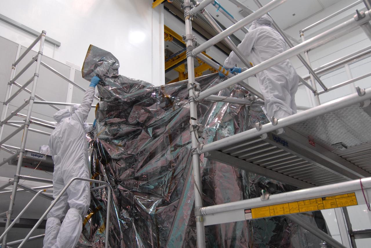 CAPE CANAVERAL, Fla. – At Astrotech Space Operations in Titusville, Fla., technicians place the protective bag around the Lunar Reconnaissance Orbiter, or LRO, before it is mated with NASA's Lunar CRater Observation and Sensing Satellite, known as LCROSS, spacecraft. The satellite's primary mission is to search for water ice on the moon in a permanently shadowed crater near one of the lunar poles. LCROSS is a low-cost, accelerated-development, companion mission to NASA's Lunar Reconnaissance Orbiter, or LRO. LCROSS and LRO are the first missions in NASA's plan to return humans to the moon and begin establishing a lunar outpost by 2020. Launch is targeted for no earlier than June 2 from Cape Canaveral Air Force Station in Florida. Photo credit: NASA/Jack Pfaller