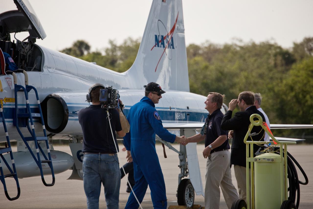 CAPE CANAVERAL, Fla. – STS-125 Commander Scott Altman (wearing cap) is greeted by Shuttle Launch Director Mike Leinbach at the Shuttle Landing Facility at NASA's Kennedy Space Center in Florida. Altman and the other members of the STS-125 crew arrived aboard T-38 training jets to get ready for launch aboard space shuttle Atlantis on May 11. Altman will be making his fourth shuttle flight. Atlantis' crew will service NASA's Hubble Space Telescope for the fifth and final time. The flight will include five spacewalks during which astronauts will refurbish and upgrade the telescope with state-of-the-art science instruments. As a result, Hubble's capabilities will be expanded and its operational lifespan extended through at least 2014. Photo credit: NASA/Jim Grossmann