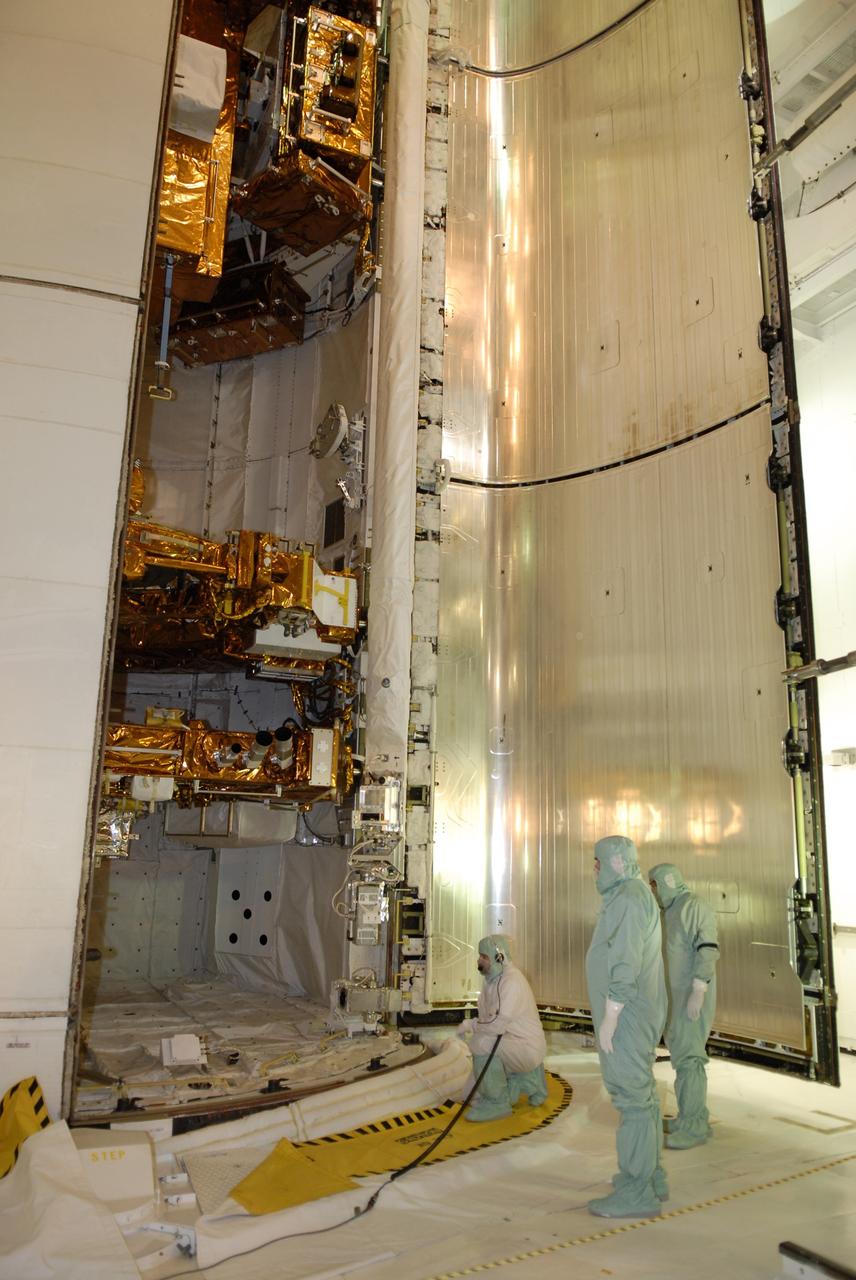 CAPE CANAVERAL, Fla. – On Launch Pad 39A at NASA's Kennedy Space Center in Florida, workers close one of space shuttle Atlantis' payload bay doors around the hardware for the STS-125 mission to service NASA's Hubble Space Telescope.  Partially concealed from view at the bottom are the Flight Support System with the Soft Capture mechanism and Multi-Use Lightweight Equipment Carrier with the Science Instrument Command and Data Handling Unit, or SIC&DH. At center is the Orbital Replacement Unit Carrier with the Cosmic Origins Spectrograph, or COS, and an IMAX 3D camera. At top is the Super Lightweight Interchangeable Carrier with the Wide Field Camera 3. Atlantis' crew will service NASA's Hubble Space Telescope for the fifth and final time. The flight will include five spacewalks during which astronauts will refurbish and upgrade the telescope with state-of-the-art science instruments. As a result, Hubble's capabilities will be expanded and its operational lifespan extended through at least 2014. Launch is scheduled for 2:01 p.m. EDT on May 11.  Photo credit: NASA/Kim Shiflett
