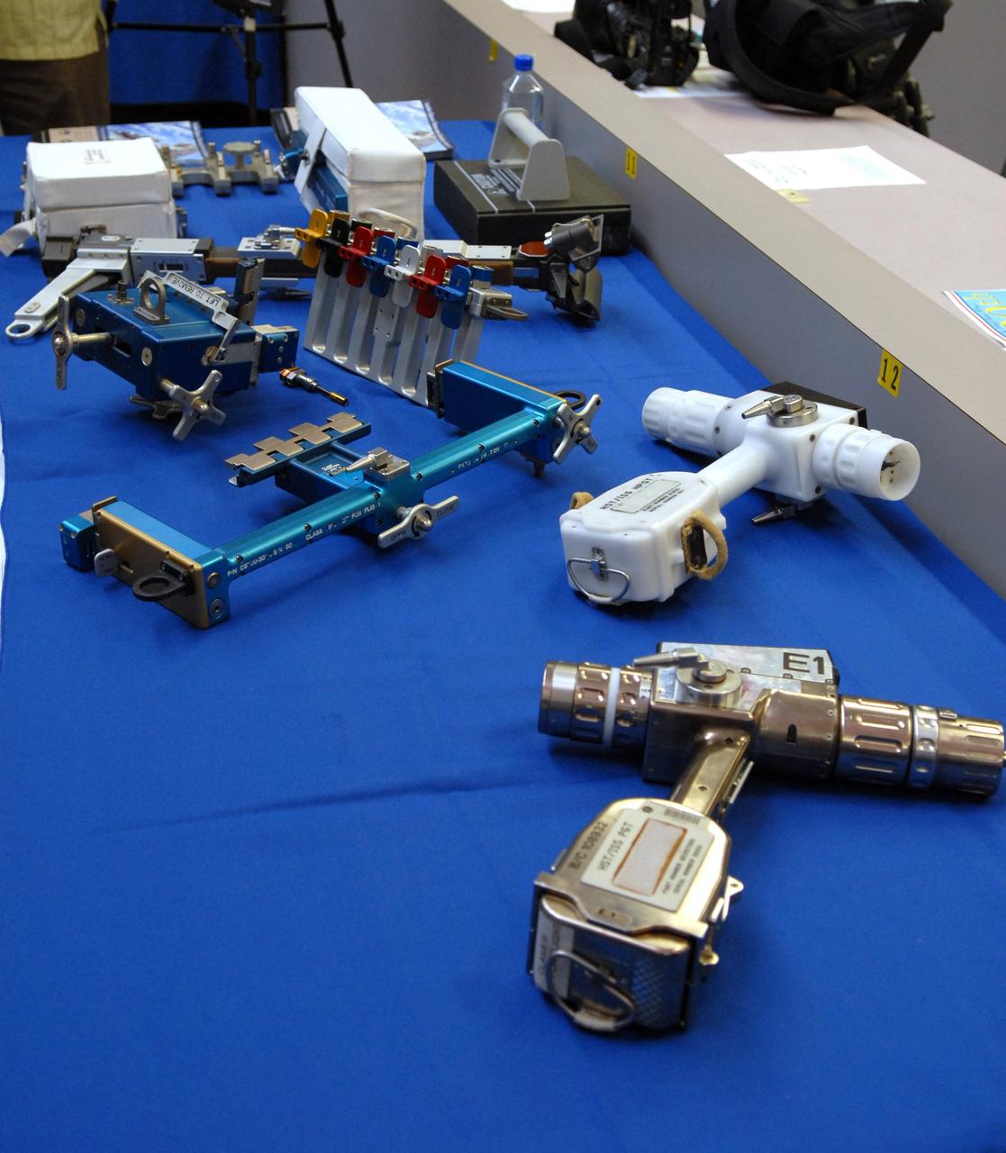 CAPE CANAVERAL, Fla. –  The tools that will be used to service NASA's Hubble Space Telescope on the STS-125 mission are displayed in the NASA News Center at NASA's Kennedy Space Center in Florida.  In the foreground is the pistol grip tool.  It can install and remove instruments, drive latches and open doors.  A self-contained, high-torque drive, the tool features an on-board computer that permits users to tailor its performance to the mission demands. Behind it is the plastic version used by astronauts during practice in the water tank at NASA' Johnson Space Center. At center left are the card extraction and insertion tools to enable removal of electronic cards. And behind those is the bit caddy. On space shuttle Atlantis’ STS-125 mission, Hubble will be serviced for the fifth and final time.  The flight will include five spacewalks during which astronauts will refurbish and upgrade the telescope with these state-of-the-art science instruments. As a result, Hubble's capabilities will be expanded and its operational lifespan extended through at least 2014.  The payload includes a Wide Field Camera 3, fine guidance sensor and the Cosmic Origins Spectrograph. Launch is scheduled for 2:01 p.m. EDT May 11.  Photo credit: NASA/Jack Pfaller