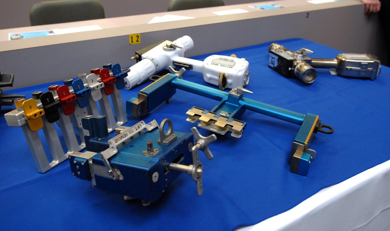 CAPE CANAVERAL, Fla. –  The tools that will be used to service NASA's Hubble Space Telescope on the STS-125 mission are displayed in the NASA News Center at NASA's Kennedy Space Center in Florida.  At far right is the pistol grip tool.  It can install and remove instruments, drive latches and open doors.  A self-contained, high-torque drive, the tool features an on-board computer that permits users to tailor its performance to the mission demands.  In the foreground are the card extraction and insertion tools to enable removal of electronic cards.  At top center is the plastic version of the pistol grip tool used by astronauts during practice in the water tank at NASA' Johnson Space Center. At center left is the bit caddy. On space shuttle Atlantis’ STS-125 mission, Hubble will be serviced for the fifth and final time.  The flight will include five spacewalks during which astronauts will refurbish and upgrade the telescope with these state-of-the-art science instruments. As a result, Hubble's capabilities will be expanded and its operational lifespan extended through at least 2014.  The payload includes a Wide Field Camera 3, fine guidance sensor and the Cosmic Origins Spectrograph. Launch is scheduled for 2:01 p.m. EDT May 11.  Photo credit: NASA/Jack Pfaller