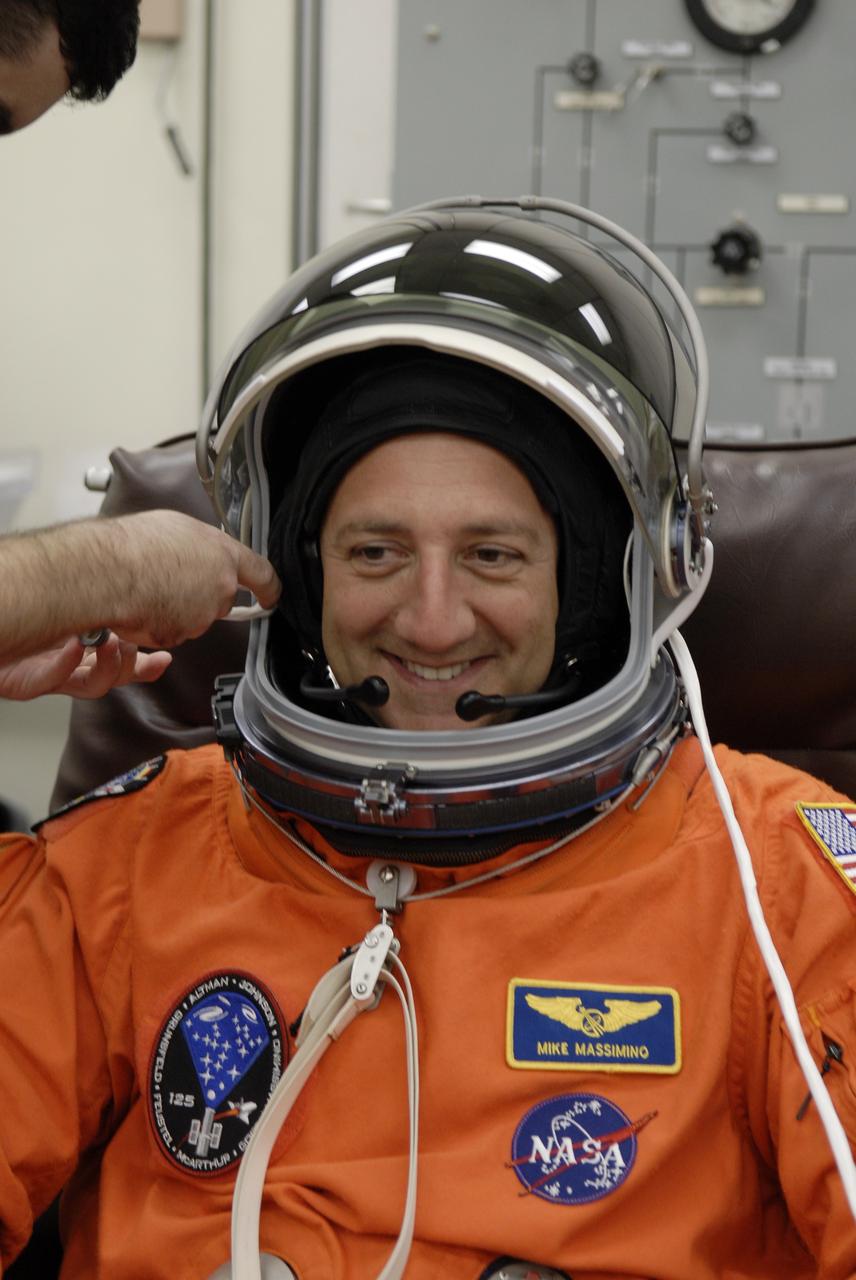CAPE CANAVERAL, Fla. –  In the Operations and Checkout Building at NASA's Kennedy Space Center in Florida, STS-125 Mission Specialist Mike Massimino is fitted with his helmet during suitup before heading for Launch Pad 39A and launch of space shuttle Atlantis.  Liftoff is scheduled for 2:01 p.m. May 11 EDT. Atlantis' 11-day flight will include five spacewalks to refurbish and upgrade NASA's Hubble Space Telescope with state-of-the-art science instruments that will expand Hubble's capabilities and extend its operational lifespan through at least 2014.  The payload includes a Wide Field Camera 3, fine guidance sensor and the Cosmic Origins Spectrograph. Photo credit: NASA/Kim Shiflett