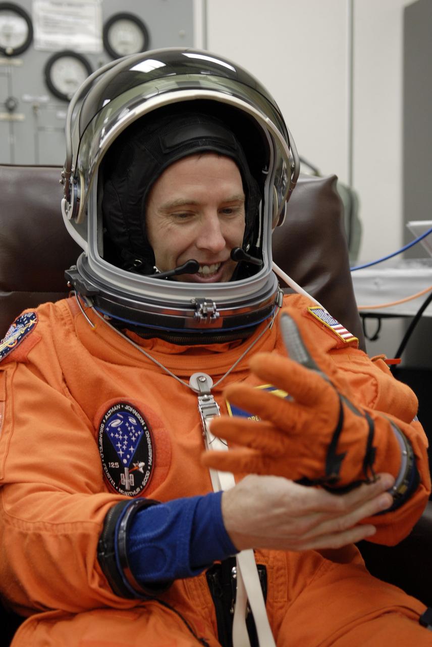 CAPE CANAVERAL, Fla. – In the Operations and Checkout Building at NASA's Kennedy Space Center in Florida, STS-125 Mission Specialist puts on his glove, checking the fit, before heading for Launch Pad 39A and launch of space shuttle Atlantis.  Liftoff is scheduled for 2:01 p.m. May 11 EDT.  Atlantis' 11-day flight will include five spacewalks to refurbish and upgrade NASA's Hubble Space Telescope with state-of-the-art science instruments that will expand Hubble's capabilities and extend its operational lifespan through at least 2014.  The payload includes a Wide Field Camera 3, fine guidance sensor and the Cosmic Origins Spectrograph. Photo credit: NASA/Kim Shiflett