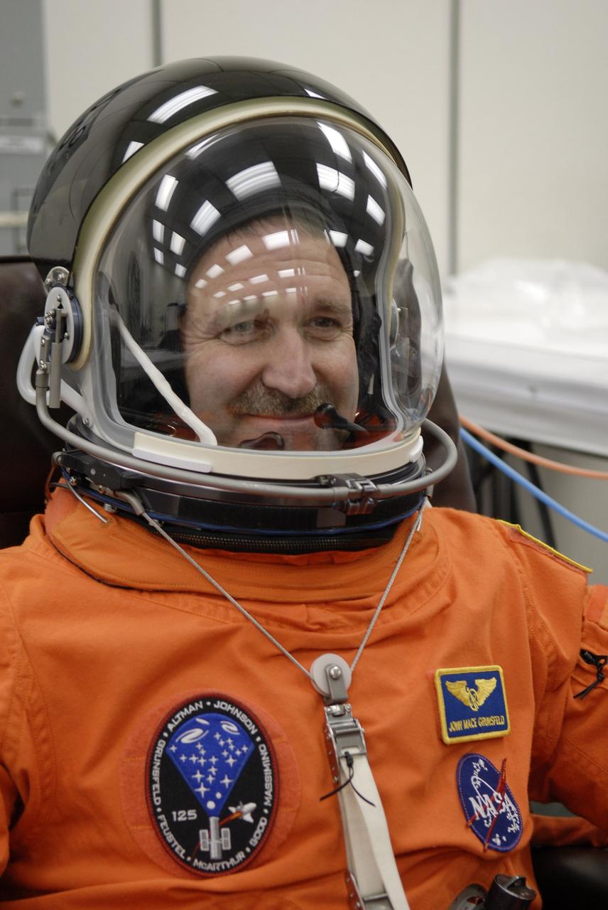 CAPE CANAVERAL, Fla. – STS-125 Mission Specialist John Grunsfeld fits the helmet on his launch-and-entry suit before heading for Launch Pad 39A at NASA's Kennedy Space Center in Florida. This launch will be Grunsfeld's fifth space shuttle flight.  Liftoff is scheduled for 2:01 p.m. May 11 EDT. Atlantis' 11-day flight will include five spacewalks to refurbish and upgrade NASA's Hubble Space Telescope with state-of-the-art science instruments that will expand Hubble's capabilities and extend its operational lifespan through at least 2014.  The payload includes a Wide Field Camera 3, fine guidance sensor and the Cosmic Origins Spectrograph. Photo credit: NASA/Kim Shiflett