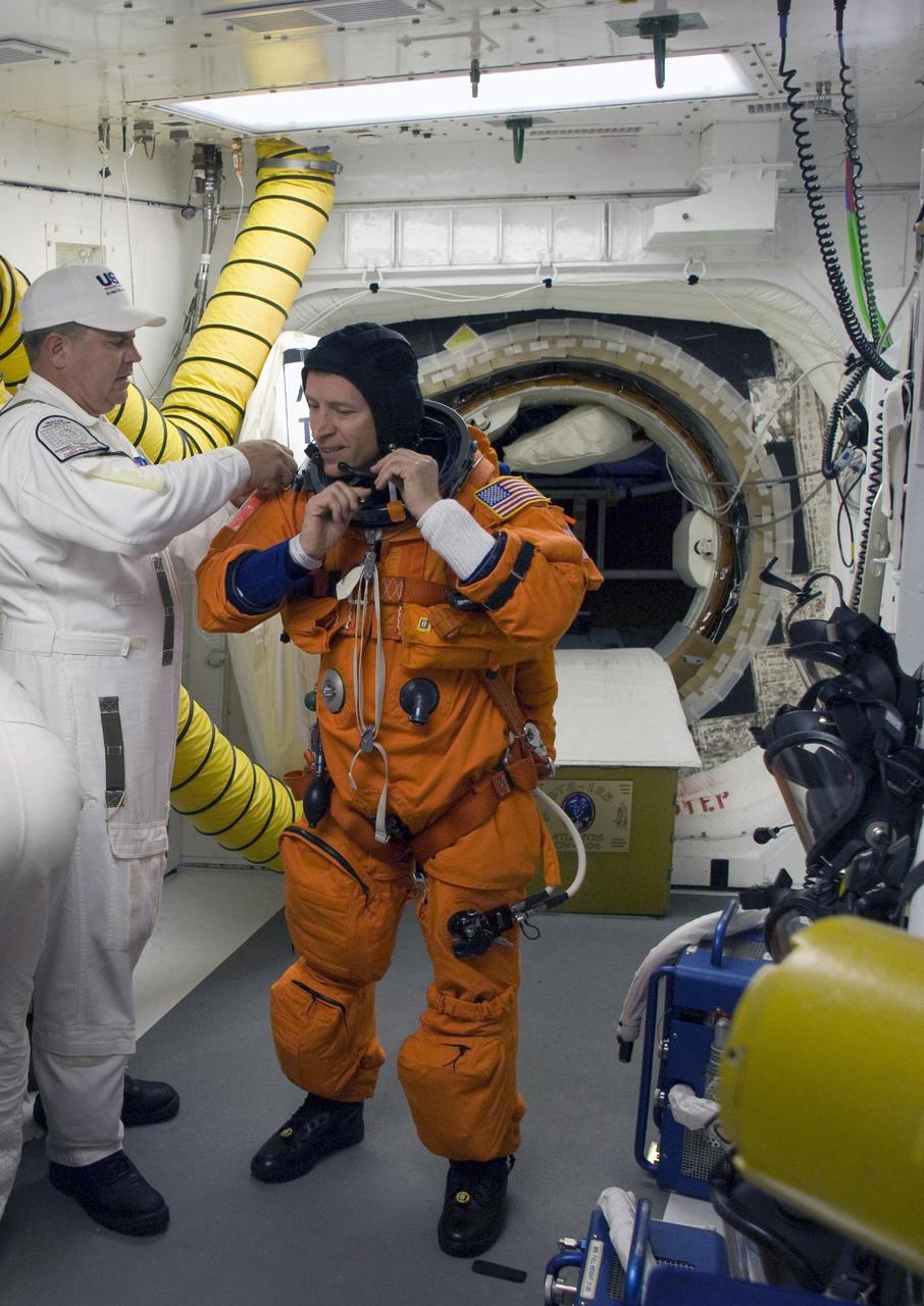 CAPE CANAVERAL, Fla. – In the White Room on Launch Pad 39A at NASA's Kennedy Space Center in Florida, STS-125 Pilot Gregory C. Johnson is helped by the closeout crew putting on his harness, which includes a parachute pack, before crawling through the open hatch into space shuttle Atlantis. The White Room is at the end of the orbiter access arm on the fixed service structure and provides access into the shuttle. Atlantis' 11-day flight will include five spacewalks to refurbish and upgrade the telescope with state-of-the-art science instruments that will expand Hubble's capabilities and extend its operational lifespan through at least 2014. The payload includes a Wide Field Camera 3, fine guidance sensor and the Cosmic Origins Spectrograph. Launch of Atlantis on the STS-125 mission is scheduled for 2:01 p.m. May 11 EDT. Photo credit: NASA/Sandra Joseph-Kevin O'Connell