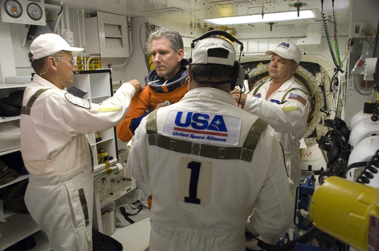 CAPE CANAVERAL, Fla. – In the White Room on Launch Pad 39A at NASA's Kennedy Space Center in Florida, STS-125 Mission Specialist Michael Good is helped by the closeout crew putting on his harness, which includes a parachute pack, before crawling through the open hatch into space shuttle Atlantis. The White Room is at the end of the orbiter access arm on the fixed service structure and provides access into the shuttle. Atlantis' 11-day flight will include five spacewalks to refurbish and upgrade the telescope with state-of-the-art science instruments that will expand Hubble's capabilities and extend its operational lifespan through at least 2014.  The payload includes a Wide Field Camera 3, fine guidance sensor and the Cosmic Origins Spectrograph. Launch of Atlantis on the STS-125 mission is scheduled for 2:01 p.m. May 11 EDT.  Photo credit: NASA/Sandra Joseph-Kevin O'Connell