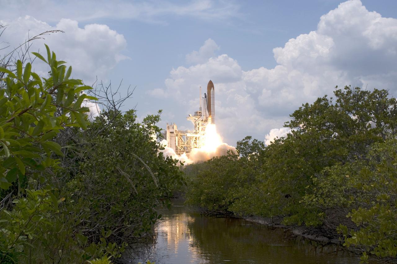 CAPE CANAVERAL, Fla. – Against a backdrop of clouds and framed below by banks of trees and bushes, space shuttle Atlantis roars off Launch Pad 39A at NASA's Kennedy Space Center in Florida for a rendezvous with NASA's Hubble Space Telescope on the STS-125 mission. Liftoff was on time at 2:01 p.m. EDT.  Atlantis' 11-day flight will include five spacewalks to refurbish and upgrade the telescope with state-of-the-art science instruments that will expand Hubble's capabilities and extend its operational lifespan through at least 2014.  The payload includes a Wide Field Camera 3, fine guidance sensor and the Cosmic Origins Spectrograph.  Photo credit: NASA/Sandra Joseph-Kevin O'Connell