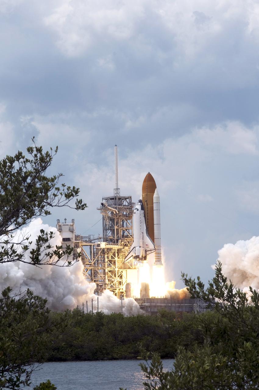 CAPE CANAVERAL, Fla. – Framed by trees in the foreground, space shuttle Atlantis lifts off from Launch Pad 39A at NASA's Kennedy Space Center in Florida atop a column of fire on the STS-125 mission.  Atlantis will rendezvous with NASA's Hubble Space Telescope. Liftoff was on time at 2:01 p.m. EDT.  Atlantis' 11-day flight will include five spacewalks to refurbish and upgrade the telescope with state-of-the-art science instruments that will expand Hubble's capabilities and extend its operational lifespan through at least 2014.  The payload includes a Wide Field Camera 3, fine guidance sensor and the Cosmic Origins Spectrograph.  Photo credit: NASA/Sandra Joseph-Kevin O'Connell