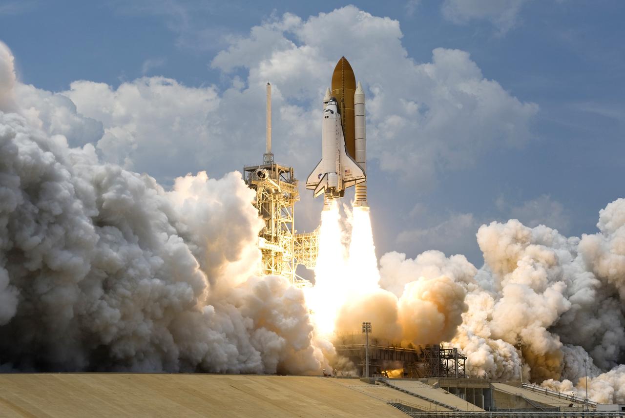 CAPE CANAVERAL, Fla. – Sandwiched by billowing clouds above and smoke and steam clouds below, space shuttle Atlantis hurtles past the lightning mast on top of the fixed service structure on Launch Pad 39A at NASA's Kennedy Space Center in Florida. Atlantis will rendezvous with NASA's Hubble Space Telescope on the STS-125 service mission. Liftoff was on-time at 2:01 p.m. EDT. Atlantis' 11-day flight will include five spacewalks to refurbish and upgrade the telescope with state-of-the-art science instruments that will expand Hubble's capabilities and extend its operational lifespan through at least 2014. The payload includes a Wide Field Camera 3, Fine Guidance Sensor and the Cosmic Origins Spectrograph. Photo courtesy of Scott Andrews