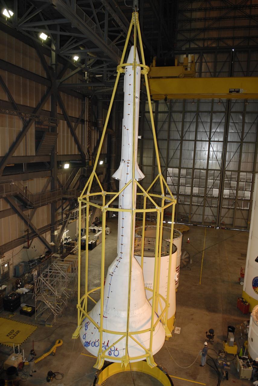 CAPE CANAVERAL, Fla. – In high bay 4 of the Vehicle Assembly Building at NASA's Kennedy Space Center in Florida, the framework known as the "birdcage" is placed over the Ares I-X simulator crew module-launch abort system, or CM-LAS.  The birdcage will be used to lift the CM-LAS to mate the stack with the simulator service module-service adapter stack.  Ares I-X is the flight test for the Ares I. The I-X flight will provide NASA an early opportunity to test and prove hardware, facilities and ground operations associated with Ares I. The launch of the 327-foot-tall, full-scale Ares I-X is targeted for August 2009.  Photo credit: NASA/Kim Shiflett