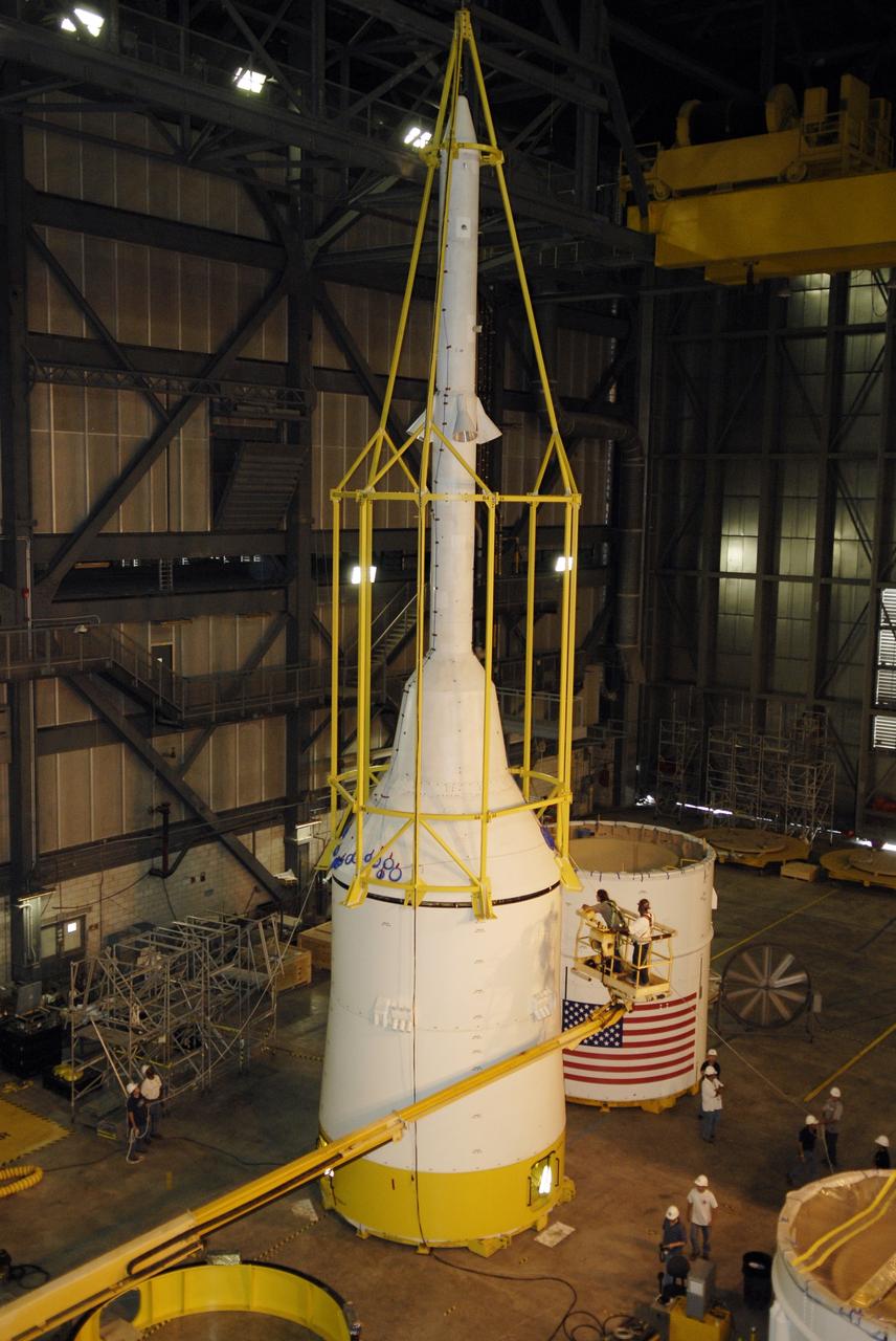 CAPE CANAVERAL, Fla. – In high bay 4 of the Vehicle Assembly Building at NASA's Kennedy Space Center in Florida, the framework known as the "birdcage" lowers the Ares I-X simulator crew module-launch abort system, or CM-LAS, onto the simulator service module-service adapter stack.  Ares I-X is the flight test for the Ares I. The I-X flight will provide NASA an early opportunity to test and prove hardware, facilities and ground operations associated with Ares I. The launch of the 327-foot-tall, full-scale Ares I-X is targeted for August 2009.  Photo credit: NASA/Kim Shiflett