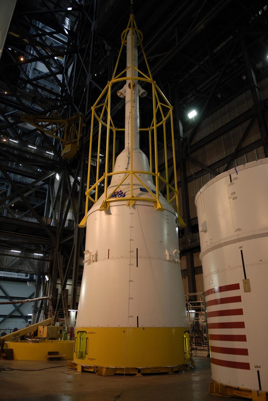 CAPE CANAVERAL, Fla. – In high bay 4 of the Vehicle Assembly Building at NASA's Kennedy Space Center in Florida, the framework known as the "birdcage" lowers the Ares I-X simulator crew module-launch abort system, or CM-LAS, onto the simulator service module-service adapter stack. Ares I-X is the flight test for the Ares I. The I-X flight will provide NASA an early opportunity to test and prove hardware, facilities and ground operations associated with Ares I. The launch of the 327-foot-tall, full-scale Ares I-X is targeted for August 2009.  Photo credit: NASA/Kim Shiflett