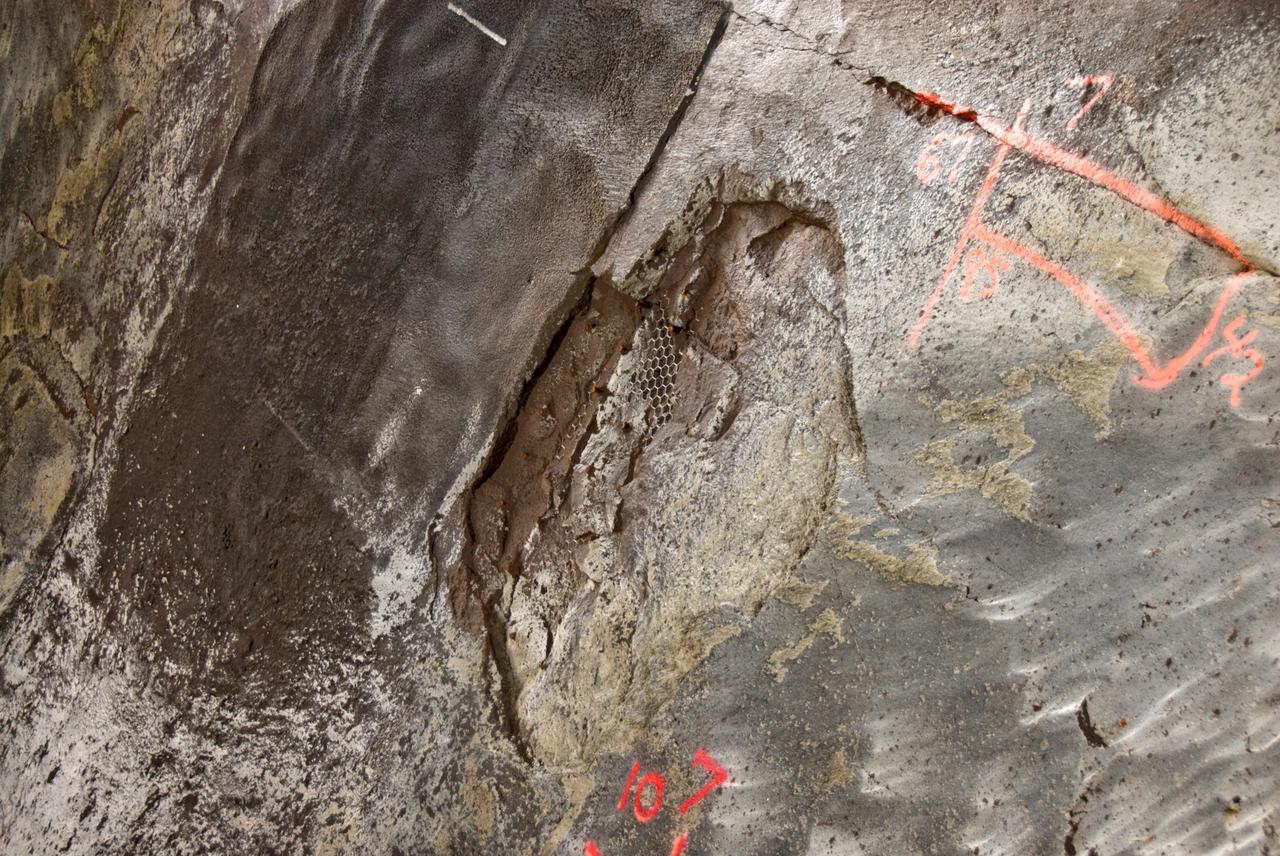 CAPE CANAVERAL, Fla. – A closeup of damage found in the Launch Pad 39A flame trench at NASA's Kennedy Space Center in Florida after launch of space shuttle Atlantis on the STS-125 mission May 11. About 25 square feet of Fondue Fyre broke off from the north side of the solid rocket booster flame deflector. The flame trench channels the flames and smoke exhaust of the shuttle's solid rocket boosters away from the space shuttle.   Fondue Fyre is a fire-resistant concrete-like material.  Some pneumatic lines (gaseous nitrogen, pressurized air) in the area also were damaged. Preliminary assessments indicated technicians can make repairs to the pad in time to support space shuttle Endeavour's targeted June 13 launch.  Photo credit: NASA/Kim Shiflett