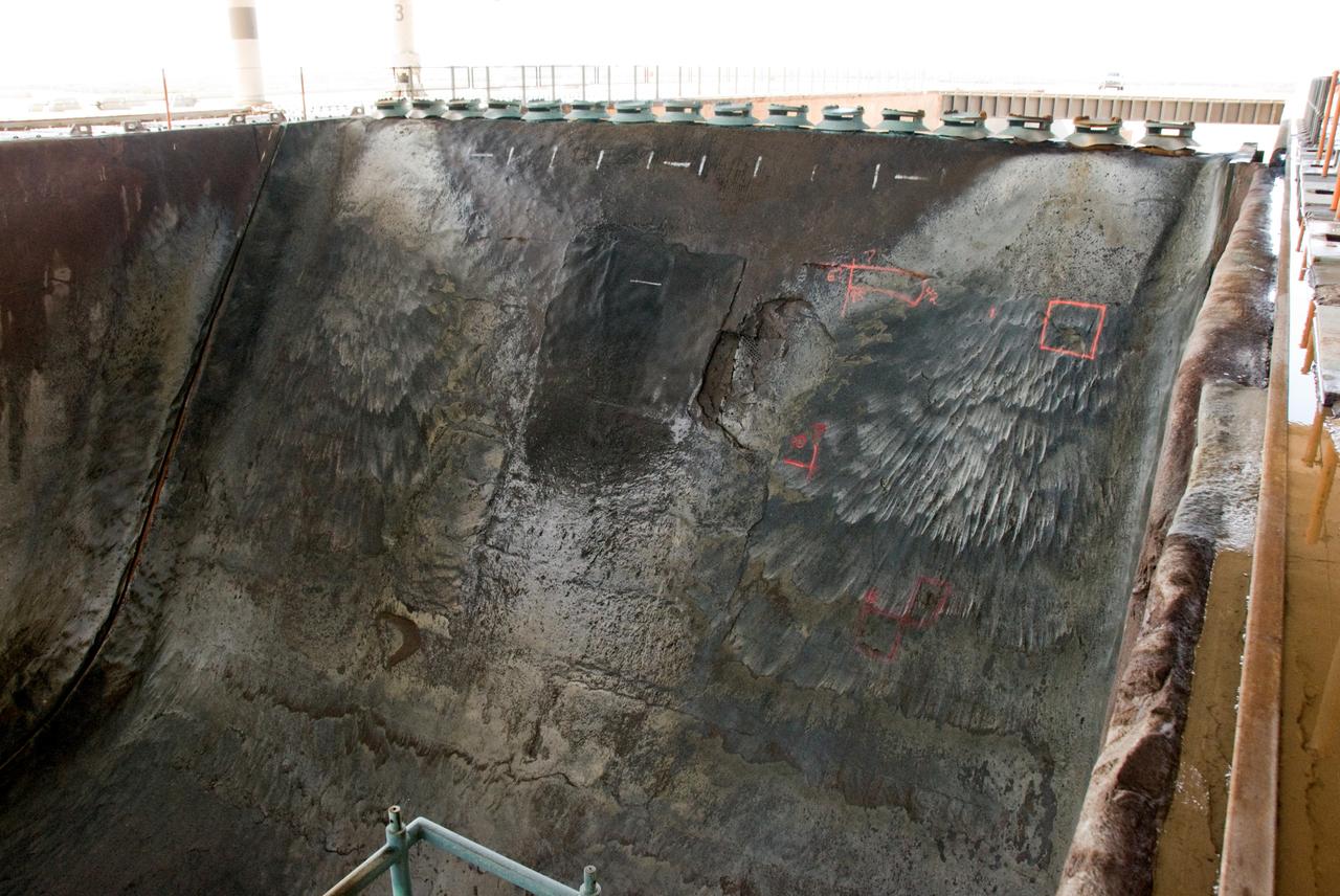 CAPE CANAVERAL, Fla. – A closeup of damage found in the Launch Pad 39A flame trench at NASA's Kennedy Space Center in Florida after launch of space shuttle Atlantis on the STS-125 mission May 11. About 25 square feet of Fondue Fyre broke off from the north side of the solid rocket booster flame deflector. The flame trench channels the flames and smoke exhaust of the shuttle's solid rocket boosters away from the space shuttle.   Fondue Fyre is a fire-resistant concrete-like material.  Some pneumatic lines (gaseous nitrogen, pressurized air) in the area also were damaged. Preliminary assessments indicated technicians can make repairs to the pad in time to support space shuttle Endeavour's targeted June 13 launch.  Photo credit: NASA/Kim Shiflett