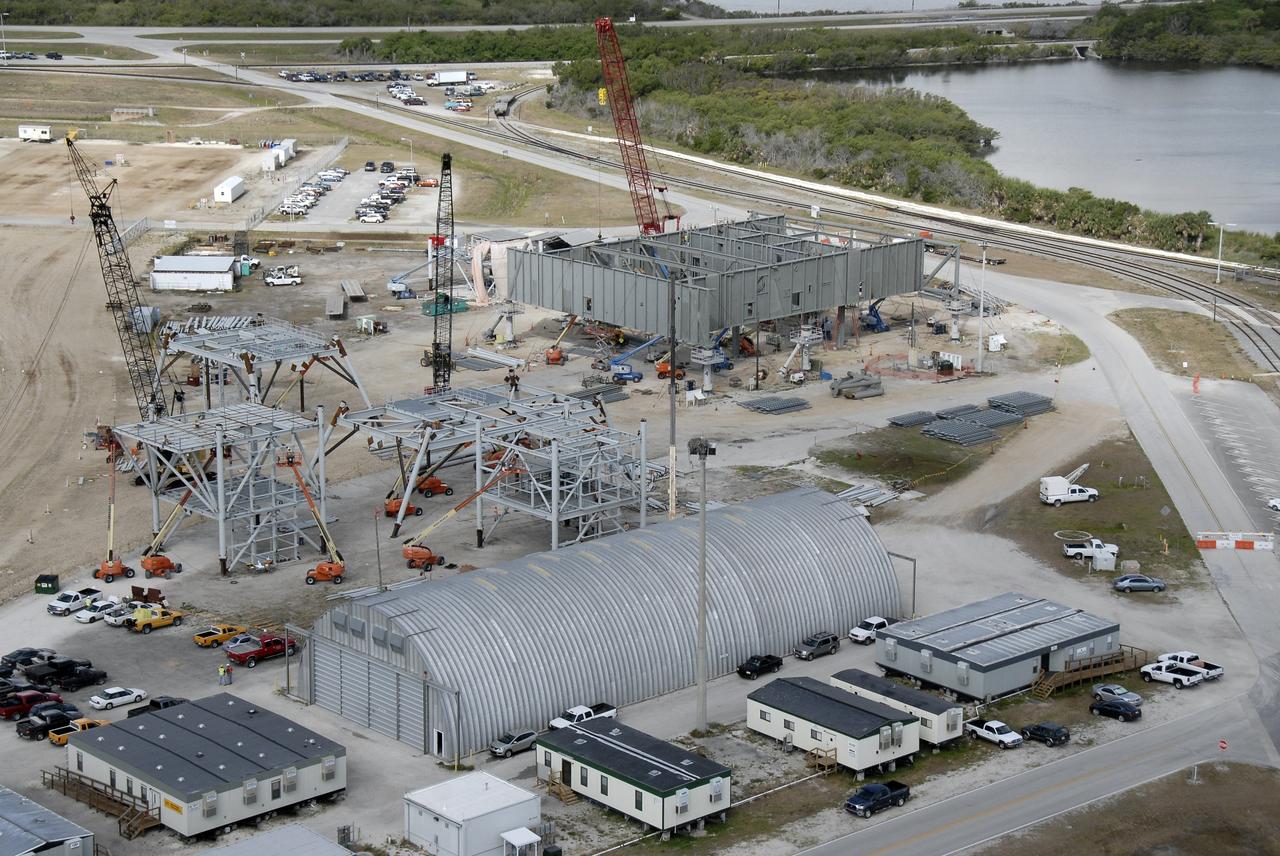 CAPE CANAVERAL, Fla. – In the mobile launcher parking area behind the Vehicle Assembly Building at NASA's Kennedy Space Center in Florida, the new mobile launcher, or ML, (at top) for the Ares rockets is under construction.  The ML will be the base to launch the Orion crew exploration vehicle and the cargo vehicle.  The base is being made lighter than space shuttle mobile launcher platforms so the crawler-transporter can pick up the added load of the 345-foot tower and taller rocket. When the structural portion of the new mobile launcher is complete, umbilicals, access arms, communications equipment and command/control equipment will be installed. Photo credit: NASA/Kim Shiflett