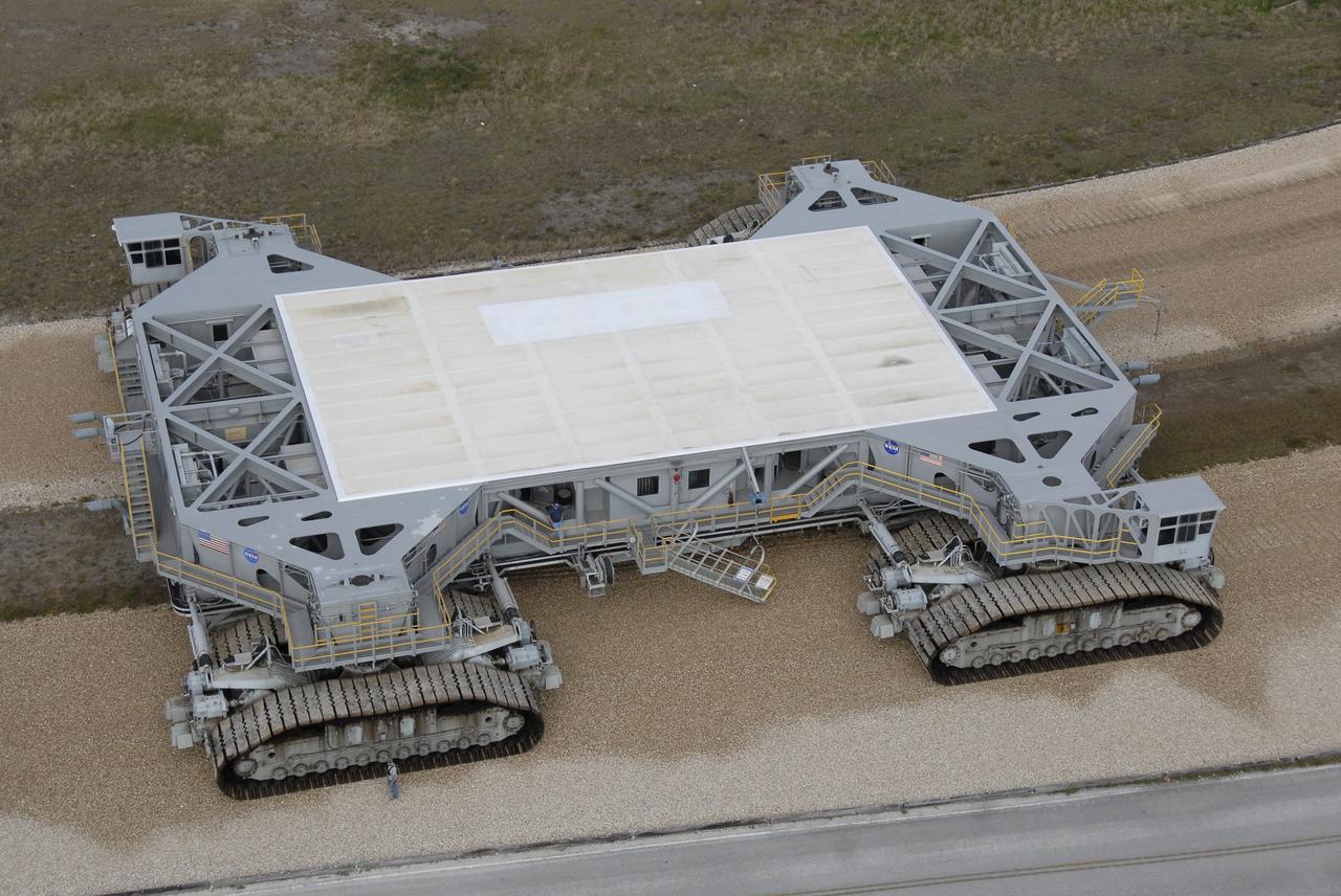 CAPE CANAVERAL, Fla. – An aerial view shows the crawler-transporter at NASA's Kennedy Space Center in Florida on the crawlerway that stretches from the Vehicle Assembly Building to the launch pads. Used now to take the shuttles to the launch pads, the crawler also will be used to move the Ares rockets on the mobile launcher, or ML, to the launch pad. A new mobile launcher is being built to launch the Orion crew exploration vehicle and the cargo vehicle. The base is being made lighter than space shuttle mobile launcher platforms so the crawler-transporter can pick up the added load of the 345-foot tower and taller rocket. When the structural portion of the new mobile launcher is complete, umbilicals, access arms, communications equipment and command/control equipment will be installed. Photo credit: NASA/Kim Shiflett