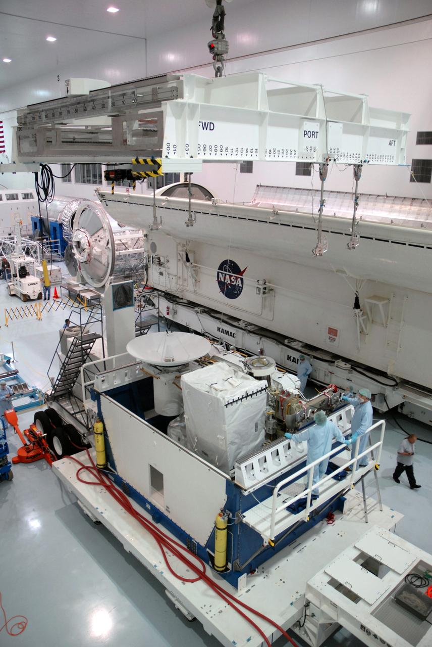CAPE CANAVERAL, Fla. – In the Space Station Processing Facility at NASA's Kennedy Space Center in Florida, an overhead crane is moved into position above the Integrated Cargo Carrier-VLD (Vertical Light Deployment), part of the payload for the STS-127 mission. The ICC-VLD will be transferred to the payload canister, behind it. The canister will deliver the ICC-VLD and other elements to Launch Pad 39A for installation in space shuttle Endeavour's payload bay. Launch is targeted for June 13. Photo credit: NASA/Troy Cryder
