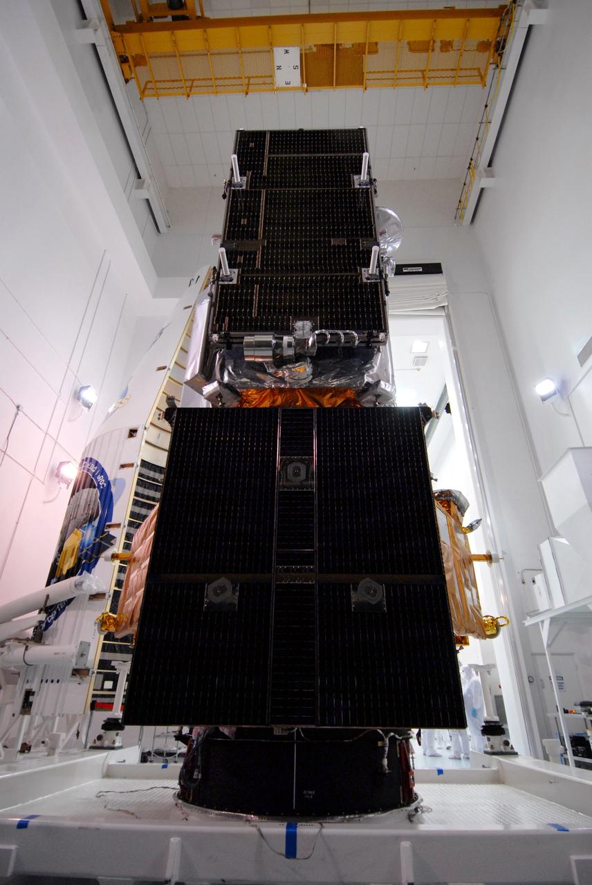 CAPE CANAVERAL, Fla. – At Astrotech Space Operations Facility in Titusville, Fla., NASA's Lunar Reconnaissance Orbiter, or LRO, and NASA's Lunar CRater Observation and Sensing Satellite, known as LCROSS,are being prepared for fairing installation. Seen here are the solar arrays. In the background at left, with the decals, is part of the fairing that will be installed around the spacecraft for launch. The fairing is a molded structure that fits flush with the outside surface of the rocket and forms an aerodynamically smooth nose cone, protecting the spacecraft during launch and ascent. The LRO includes five instruments: DIVINER, LAMP, LEND, LOLA and LROC. They will be launched aboard an Atlas V/Centaur rocket no earlier than June 17 from Launch Complex-41 on Cape Canaveral Air Force Station in Florida. Photo credit: NASA/Jack Pfaller