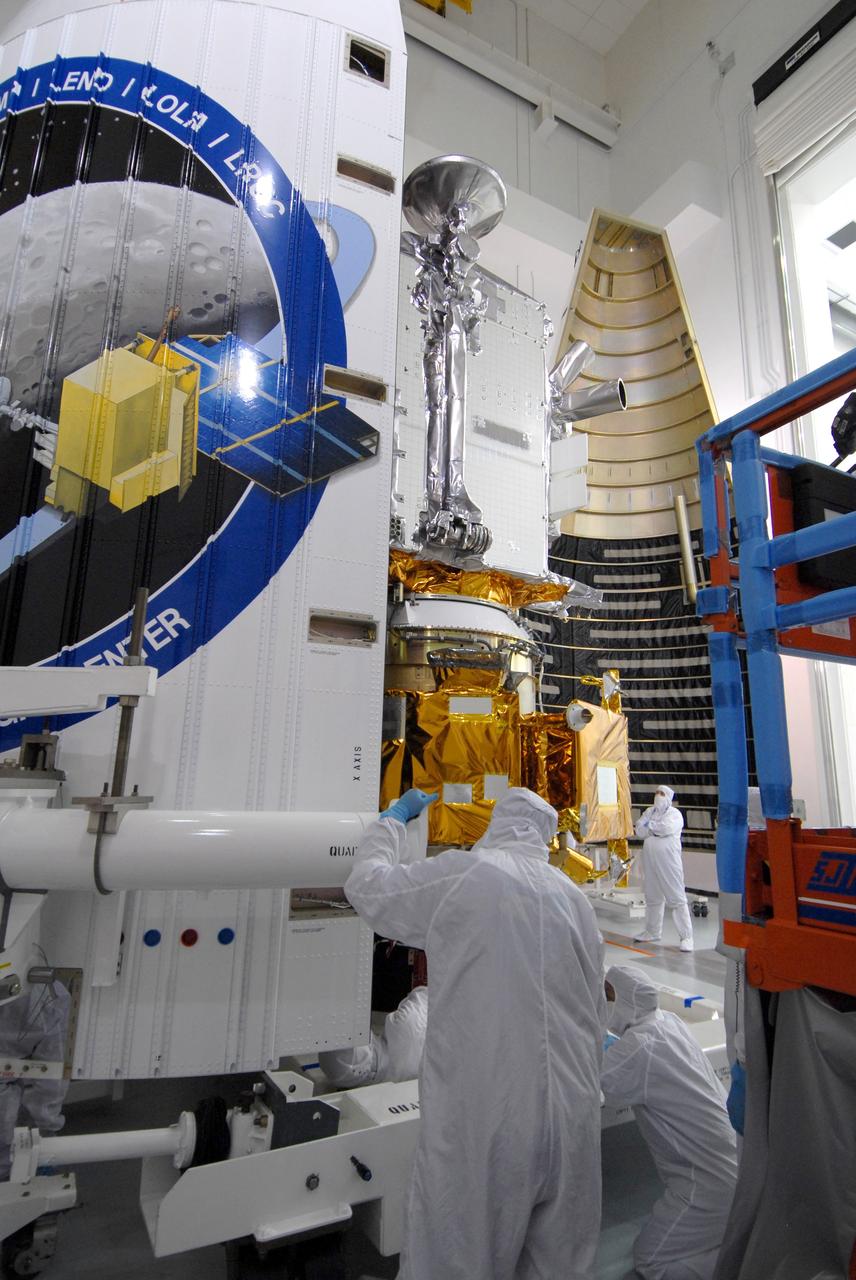 CAPE CANAVERAL, Fla. – At Astrotech Space Operations Facility in Titusville, Fla., technicians move the first half of the fairing toward NASA's Lunar Reconnaissance Orbiter, or LRO, with NASA's Lunar Crater Observation and Sensing Satellite, known as LCROSS, for installation. The fairing is a molded structure that fits flush with the outside surface of the rocket and forms an aerodynamically smooth nose cone, protecting the spacecraft during launch and ascent. The LRO includes five instruments:  DIVINER, LAMP, LEND, LOLA and LROC.  They will be launched aboard an Atlas V/Centaur rocket no earlier than June 17 from Launch Complex-41 on Cape Canaveral Air Force Station in Florida.  Photo credit: NASA/Jack Pfaller