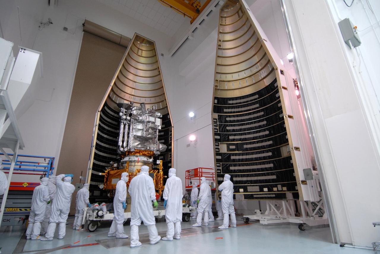 CAPE CANAVERAL, Fla. – At Astrotech Space Operations Facility in Titusville, Fla., technicians closely watch as the first half of the fairing is moved into place for installation around NASA's Lunar Reconnaissance Orbiter, or LRO, and and NASA's Lunar Crater Observation and Sensing Satellite, known as LCROSS. At right is the second half. The fairing is a molded structure that fits flush with the outside surface of the rocket and forms an aerodynamically smooth nose cone, protecting the spacecraft during launch and ascent. The LRO includes five instruments: DIVINER, LAMP, LEND, LOLA and LROC. They will be launched aboard an Atlas V/Centaur rocket no earlier than June 17 from Launch Complex-41 on Cape Canaveral Air Force Station in Florida. Photo credit: NASA/Jack Pfaller