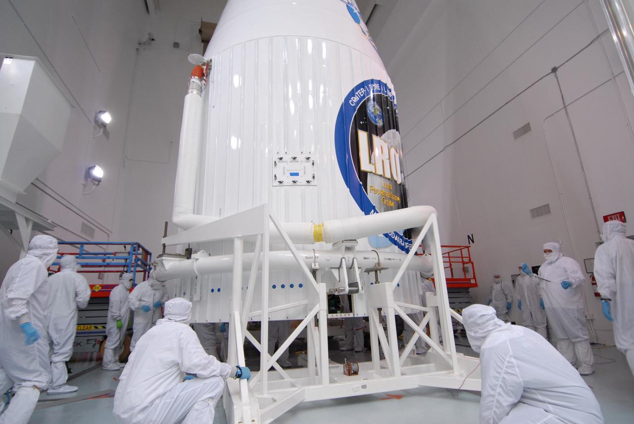 CAPE CANAVERAL, Fla. – At Astrotech Space Operations Facility in Titusville, Fla., technicians closely watch the joining of the fairing halves around NASA's Lunar Reconnaissance Orbiter, or LRO, and and NASA's Lunar Crater Observation and Sensing Satellite, known as LCROSS.  The fairing is a molded structure that fits flush with the outside surface of the rocket and forms an aerodynamically smooth nose cone, protecting the spacecraft during launch and ascent. The LRO includes five instruments:  DIVINER, LAMP, LEND, LOLA and LROC.  They will be launched aboard an Atlas V/Centaur rocket no earlier than June 17 from Launch Complex-41 on Cape Canaveral Air Force Station in Florida.  Photo credit: NASA/Jack Pfaller