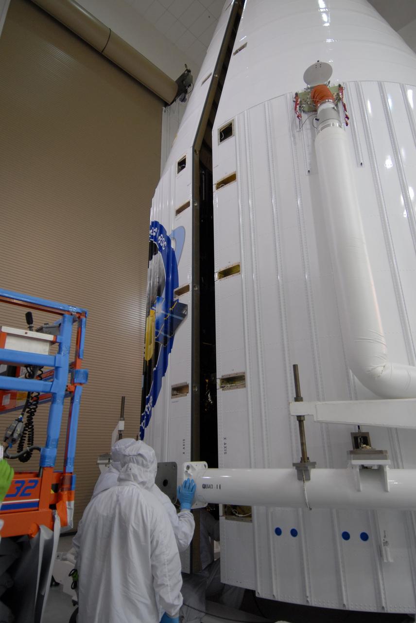 CAPE CANAVERAL, Fla. – At Astrotech Space Operations Facility in Titusville, Fla., technicians closely watch as the fairing halves move together to enclose NASA's Lunar Reconnaissance Orbiter, or LRO, and NASA's Lunar Crater Observation and Sensing Satellite, known as LCROSS.  The fairing is a molded structure that fits flush with the outside surface of the rocket and forms an aerodynamically smooth nose cone, protecting the spacecraft during launch and ascent. The LRO includes five instruments:  DIVINER, LAMP, LEND, LOLA and LROC.  They will be launched aboard an Atlas V/Centaur rocket no earlier than June 17 from Launch Complex-41 on Cape Canaveral Air Force Station in Florida.  Photo credit: NASA/Jack Pfaller