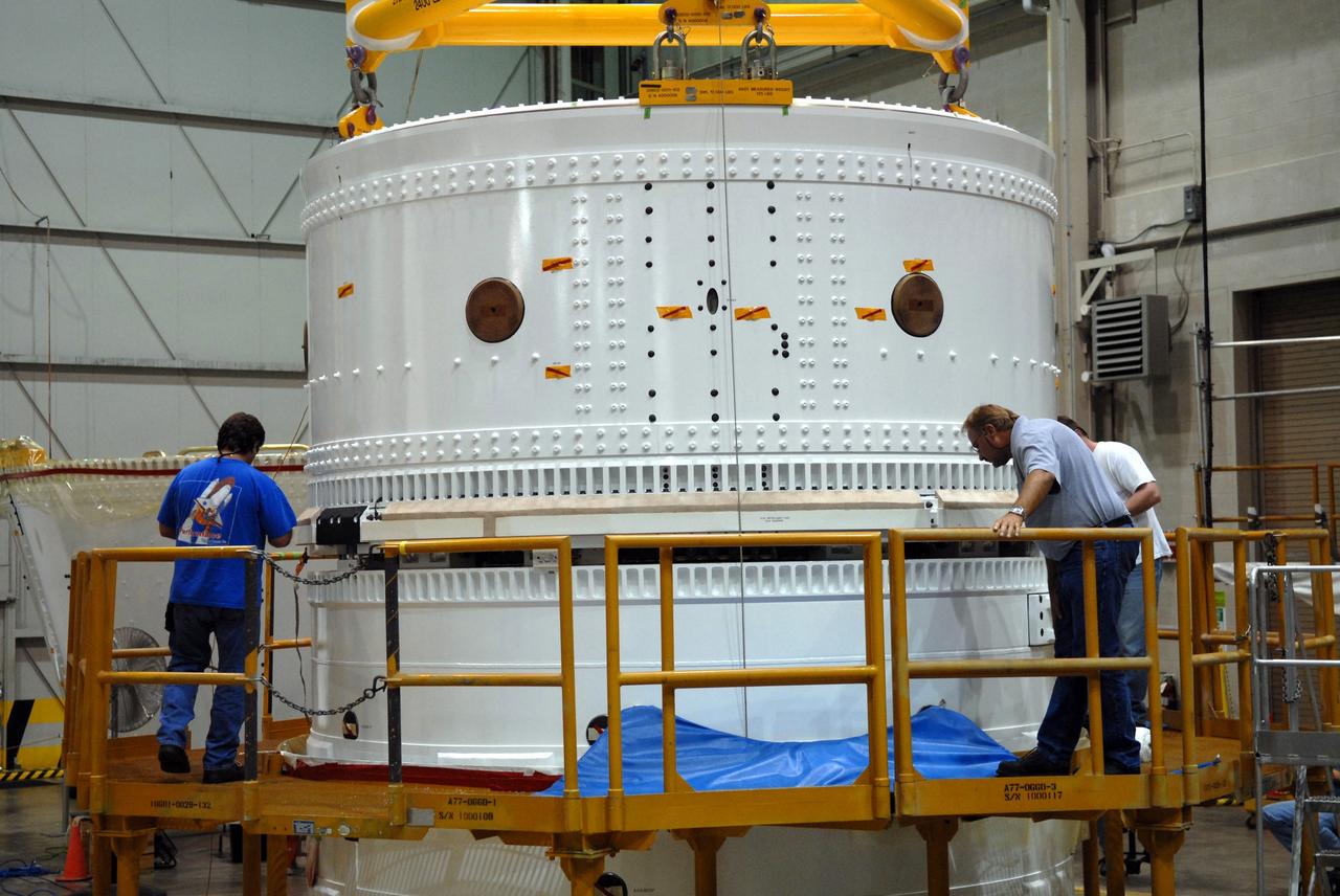CAPE CANAVERAL, Fla. – In the Assembly and Refurbishment Facility at NASA's Kennedy Space Center in Florida, technicians examine the assembly of the Ares I-X forward skirt and the forward skirt extension. The forward skirt is the initial piece of first-stage hardware in preparation for the August 2009 test flight of NASA's next-generation spacecraft and launch vehicle system. Built entirely of armored steel, the 14,000-pound segment is seven feet tall and 12-1/4 feet wide.   Photo credit: NASA/Tim Jacobs