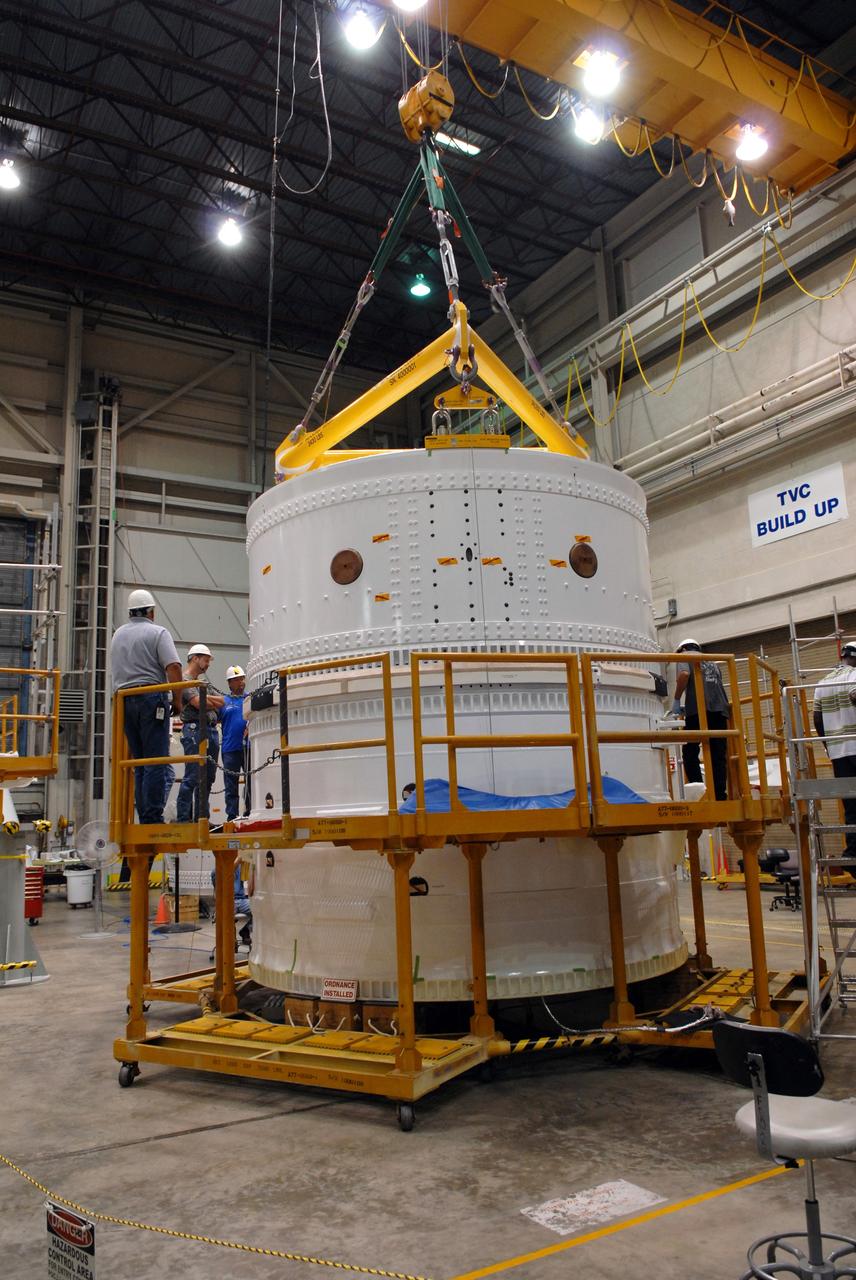 CAPE CANAVERAL, Fla. – In the Assembly and Refurbishment Facility at NASA's Kennedy Space Center in Florida, technicians examine the assembly of the Ares I-X forward skirt and the forward skirt extension. The forward skirt is the initial piece of first-stage hardware in preparation for the August 2009 test flight of NASA's next-generation spacecraft and launch vehicle system. Built entirely of armored steel, the 14,000-pound segment is seven feet tall and 12-1/4 feet wide.   Photo credit: NASA/Tim Jacobs