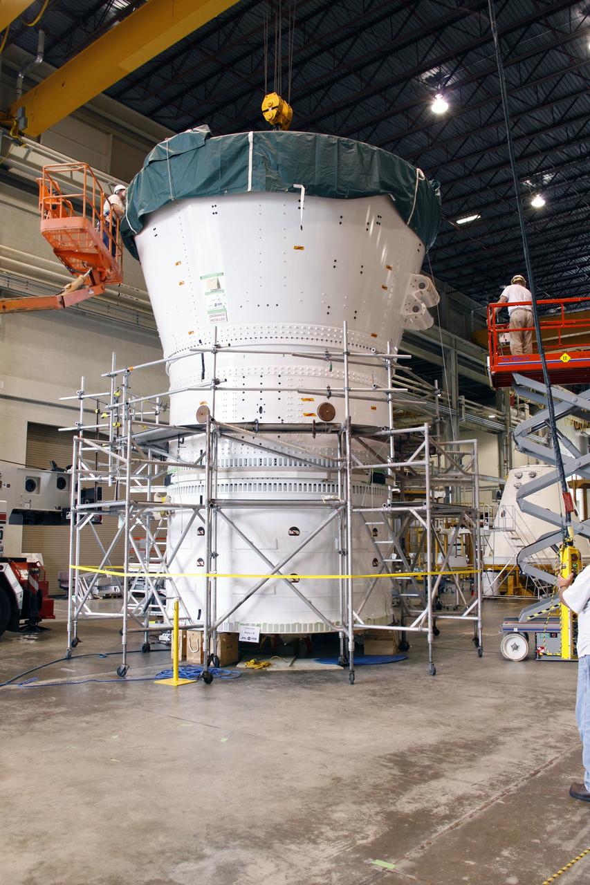 CAPE CANAVERAL, Fla. – In the Assembly and Refurbishment Facility at NASA's Kennedy Space Center in Florida, the Ares I-X frustum is being mated to the forward skirt and forward skirt extension to complete the forward assembly. The assembly will be moved to the Vehicle Assembly Building for stacking operations. Resembling a giant funnel, the frustum's function is to transition the primary flight loads from the rocket's upper stage to the first stage. The frustum is located between the forward skirt extension and the upper stage of the Ares I-X. The launch of Ares I-X is targeted for August 2009. Photo credit: NASA/Troy Cryder